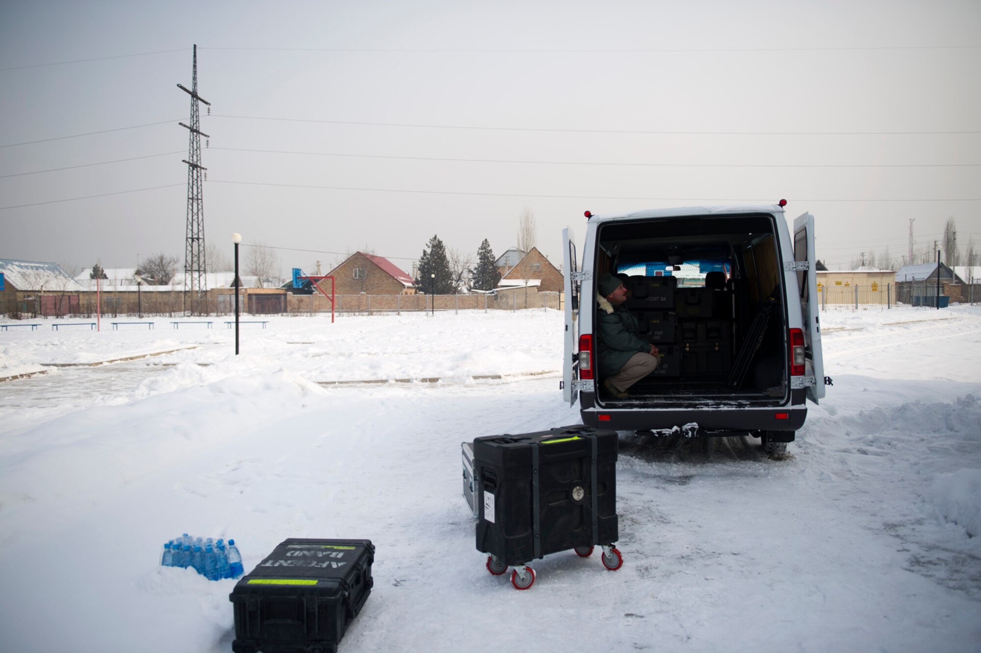 Sitting inside of the band's cargo van, Master Sgt. Lawrence Price, bass player for the U.S. Air Forces Central Band Afterburner, waits to load the van in sub freezing temperatures outside of Bishkek, Kyrgyzstan Feb. 4, 2012. Earlier in the day, the band played for more than 100 students here. (U.S. Air Force photo by Staff Sgt. David Salanitri/Released)
