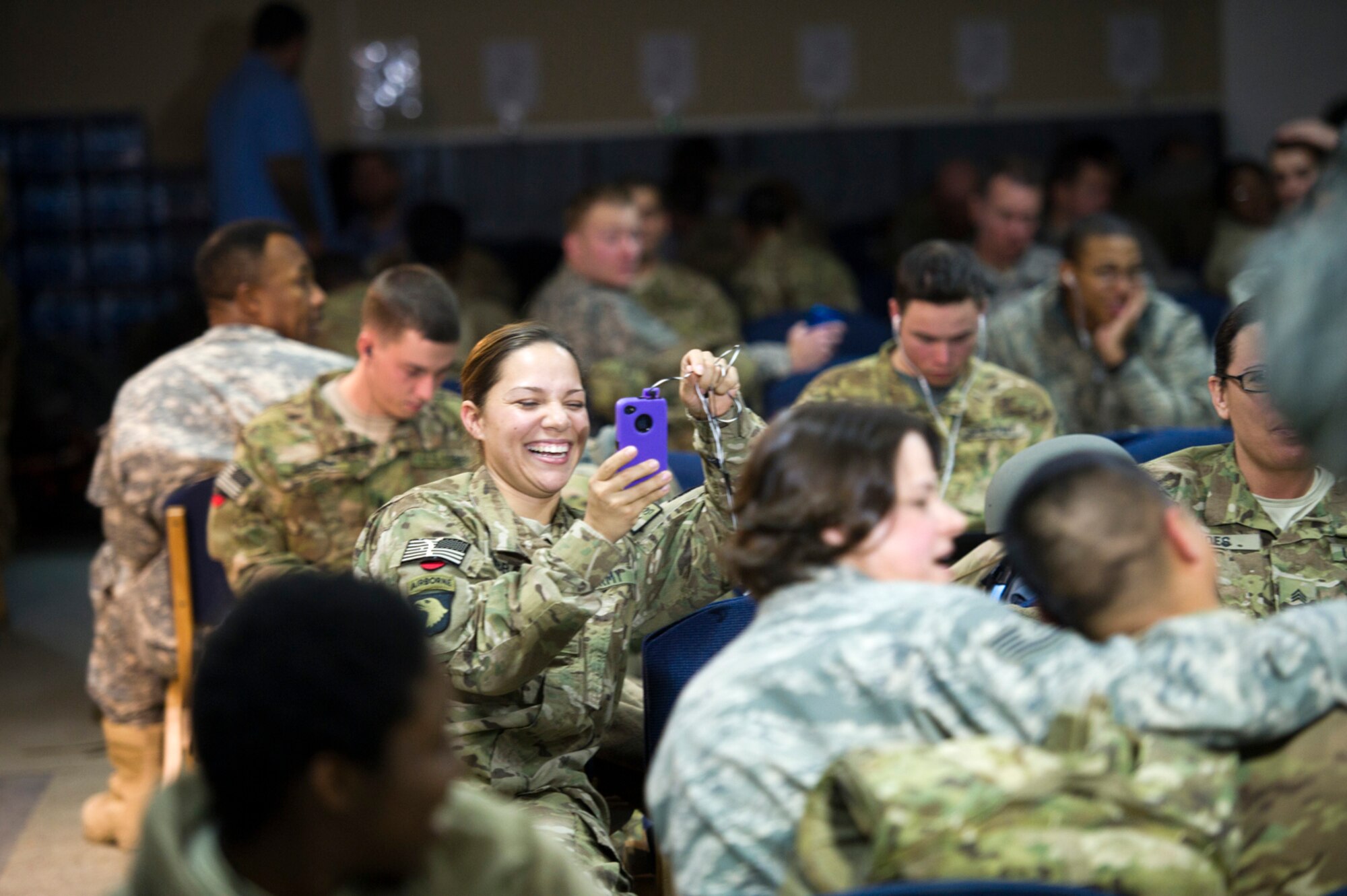 An Army Soldier video tapes her teammate being sang to by Tech. Sgt. Kim Lively, lead vocalist for the U.S. Air Forces Central Band Afterburner at the Transit Center at Manas, Kyrgyzstan Jan. 30, 2012.  At this performance, Afterburner played for troops who were only hours away from deploying to Afghanistan.  (U.S. Air Force photo by Staff Sgt. David Salanitri/Released)
