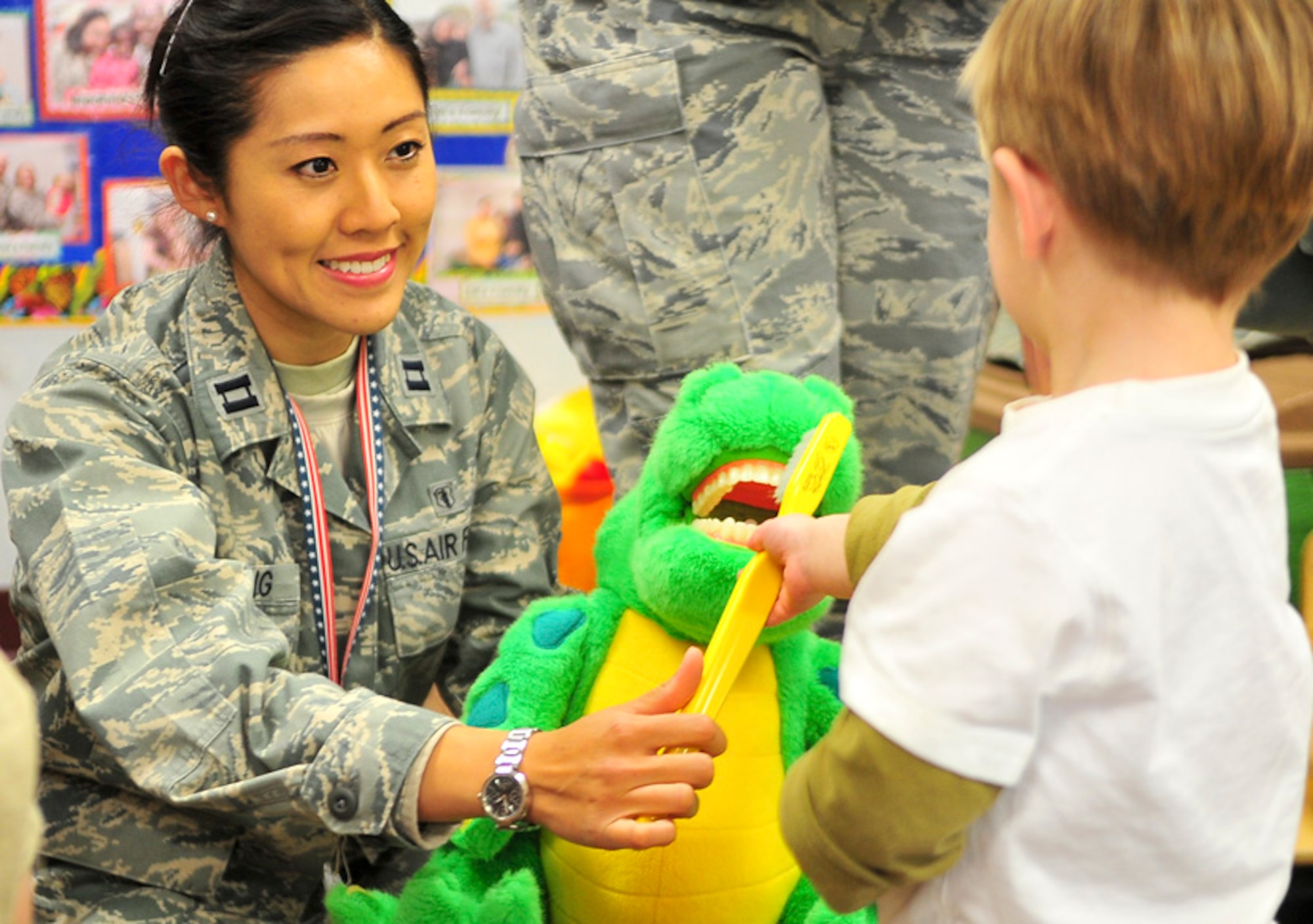 Capt. Wah-Yung Tsang, 51st Dental Squadron preventive dentistry officer-in-charge, observes as children from the elementary school demonstrate how they brush their teeth, Feb. 9, 2012. Tsang and other members from the 51st Dental Squadron are presenting oral health briefings and distributing oral hygiene goody bags throughout the month of February, which is designated as National Children’s Dental Health Month. (U.S. Air Force photo/Senior Airman Adam Grant)