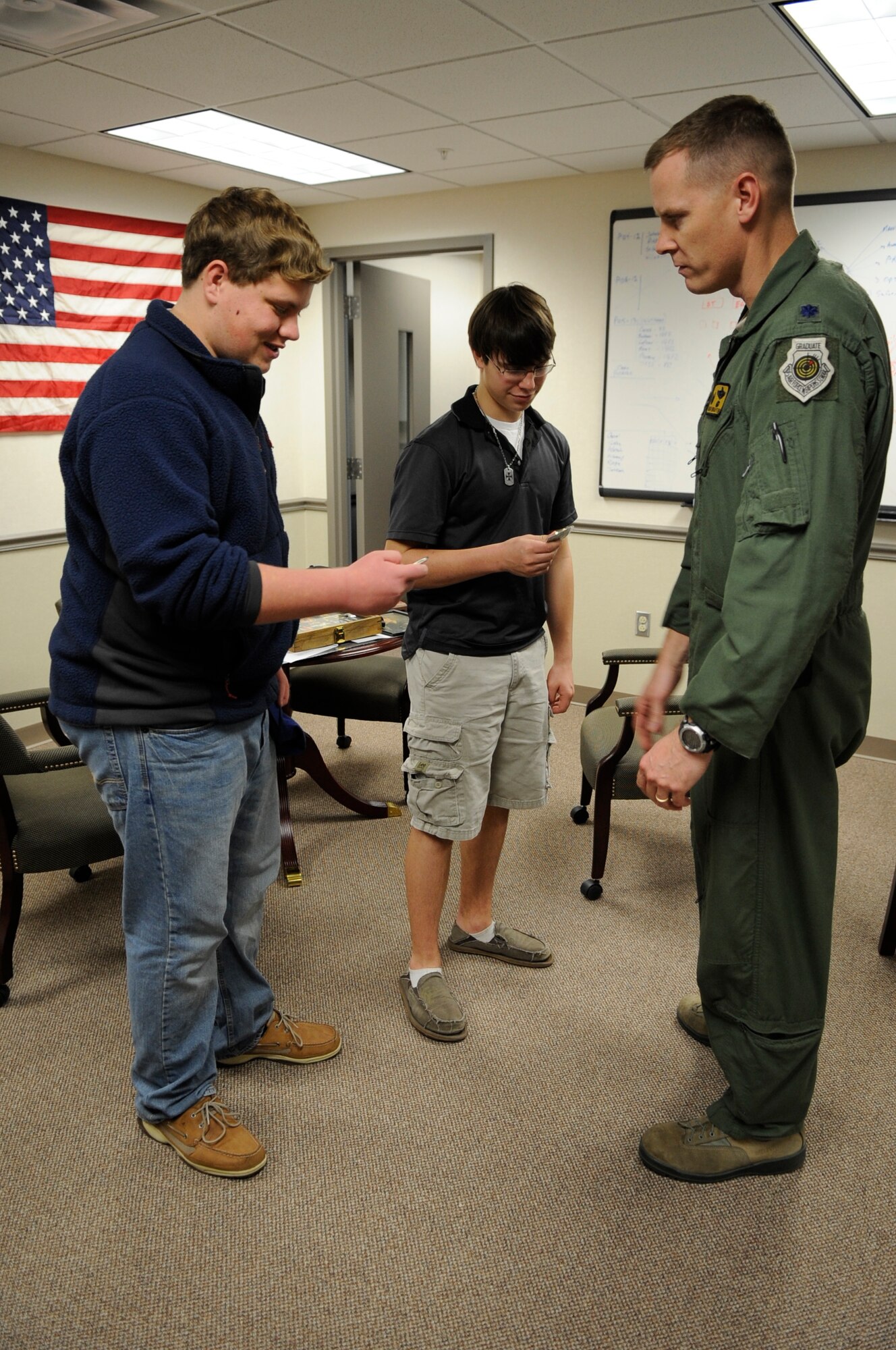Lane Williams and Nathan Naranjo, Greenacres Middle School students, take a look at the coins they received from Lt. Col. William Wharton, 11th Bomb Squadron commander, at Barksdale Air Force Base, La., Feb. 2. Wharton presented coins to students after speaking with them about becoming pilots. The students visited Barksdale as part of their middle school's job-shadowing program. (U.S. Air Force photo/Airman 1st Class Andrea F. Liechti)(RELEASED)