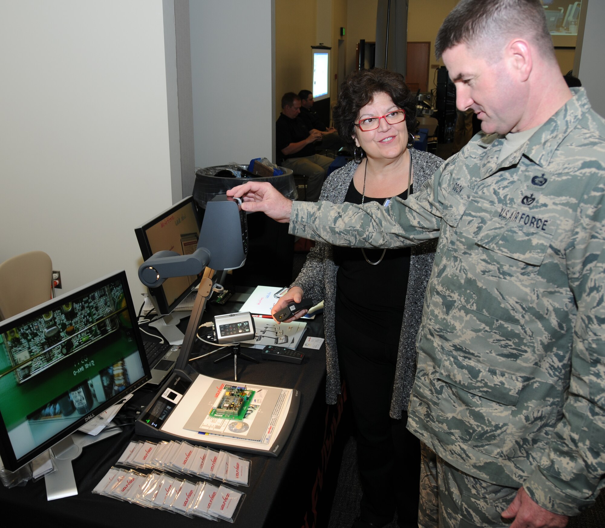 Elaine Liner, WolfVision regional sales manager, allows Master Sgt. Jay Cook, 335th Training Squadron, to control a high-definition camera used for training during a technology expo Jan. 9, 2012, at the Roberts Consolidated Aircraft Maintenance Facility, Keesler Air Force Base, Miss.  The 17th annual free expo, hosted by the 81st Training Support Squadron, featured more than 40 exhibitors.  (U.S. Air Force photo by Kemberly Groue)