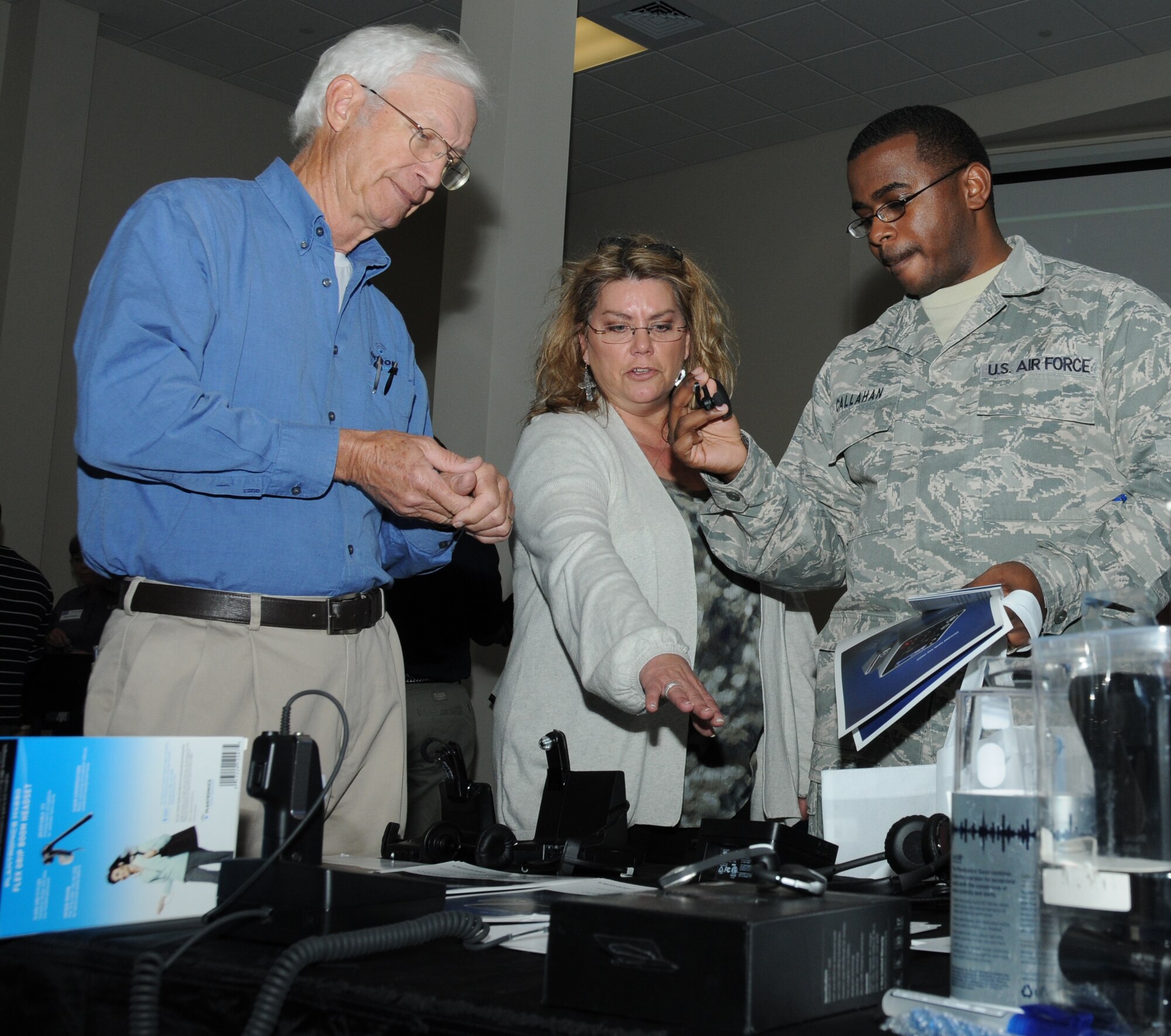 Charles Green and Sheryl Barrios, Plantronics sales representatives, describes the hands-free sound and voice equipment used for communication to Staff Sgt. Vincent Callahan, 81st Training Support Squadron, during a technology expo Jan. 9, 2012, at the Roberts Consolidated Aircraft Maintenance Facility, Keesler Air Force Base, Miss.  The 17th annual free expo, hosted by the 81st TRSS, featured more than 40 exhibitors.  (U.S. Air Force photo by Kemberly Groue)