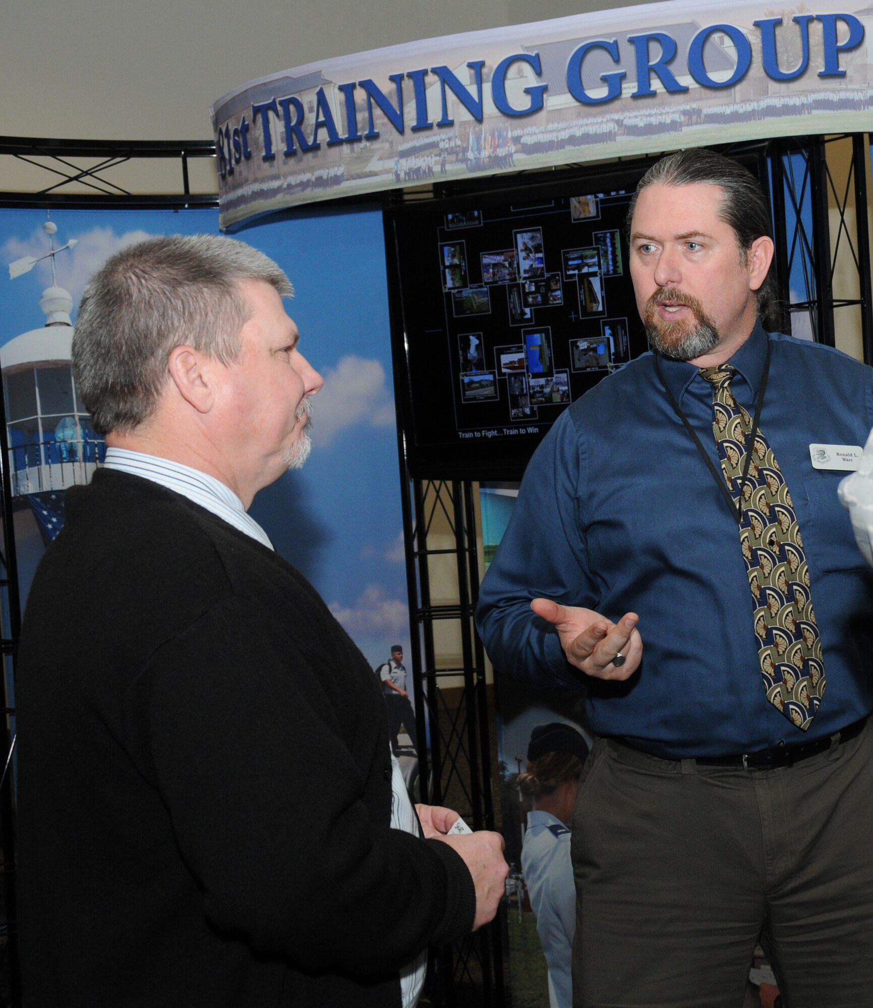 Mike Ritter, 2nd Air Force, discusses the future of technical training development within the Air Force Instructional Technology Units with Ronald Warr, 81st Training Support Squadron, during a technology expo Jan. 9, 2012, at the Roberts Consolidated Aircraft Maintenance Facility, Keesler Air Force Base, Miss.  The 17th annual free expo, hosted by the 81st TRSS, featured more than 40 exhibitors.  (U.S. Air Force photo by Kemberly Groue)