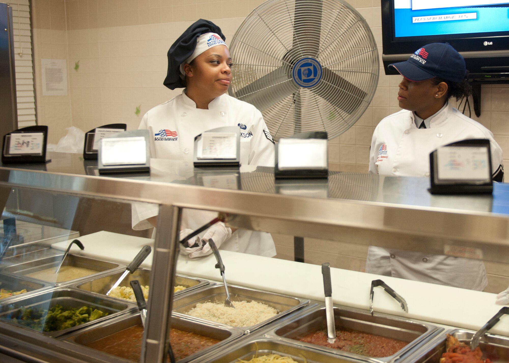 U.S. Air Force Senior Airman Maneca Jackson, 23d Force Support Squadron, speaks with inspector Master Sgt. Nichelle Jenkins, Headquarters Air Force Services Agency at Lackland Air Force Base, Texas, during an inspection for the Air Force-level John L. Hennessy award at the Georgia Pines Dining Facility, Feb. 10, 2012, at Moody Air Force Base, Ga. Some of the inspection consisted of interviews with dining facility Airmen, checking food quality and ensuring safety guidelines are being followed. If the 23d FSS can meet their expectations more than the competing team, Moody will take the title of the best multiple-facility dining facility. (U.S. Air Force photo by Senior Airman Eileen Meier/Released)

