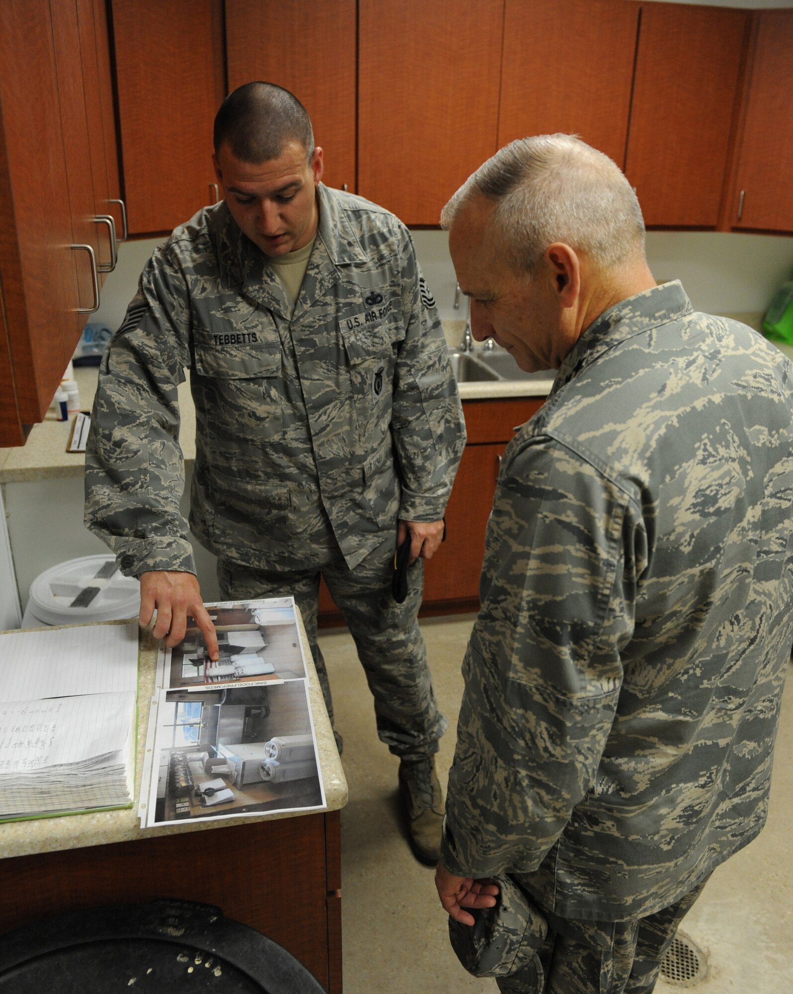 Tech. Sgt. Clayton Tebbetts, 2nd Security Forces Squadron  Military Working Dog kennel master, shows Lt. Gen. Jim Kowalski, Air Force Global Strike Command commander, photos of old Barksdale Air Force Base kennels. Recently, the 2nd SFS received a new facility for MWDs and their handlers. The new facility is equipped with heated and cooled floors, keeping the dogs warmer in the winter and cooler in the summer. Kowalski visited the wing Feb. 3. (U.S. Air Force photo/Airman 1st Class Micaiah Anthony)(RELEASED)