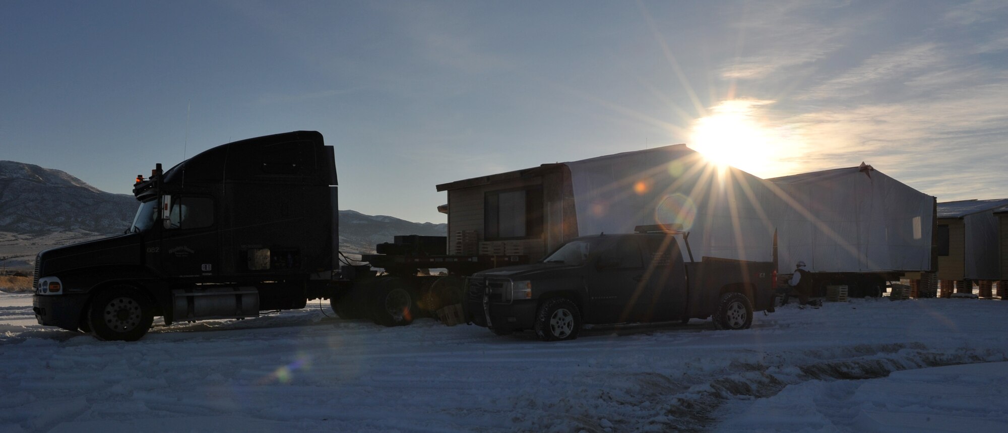 A house sits on a truck bed while workers build a temporary platform that will hold it until a foundation can be poured, Jan. 25, 2012, in Ely, Nevada. The houses have been brought to Ely from Mountain Home Air Force base as part of Operation Walking Shield. (U.S. Air Force photo by Airman 1st Class Heather Hayward/Released)