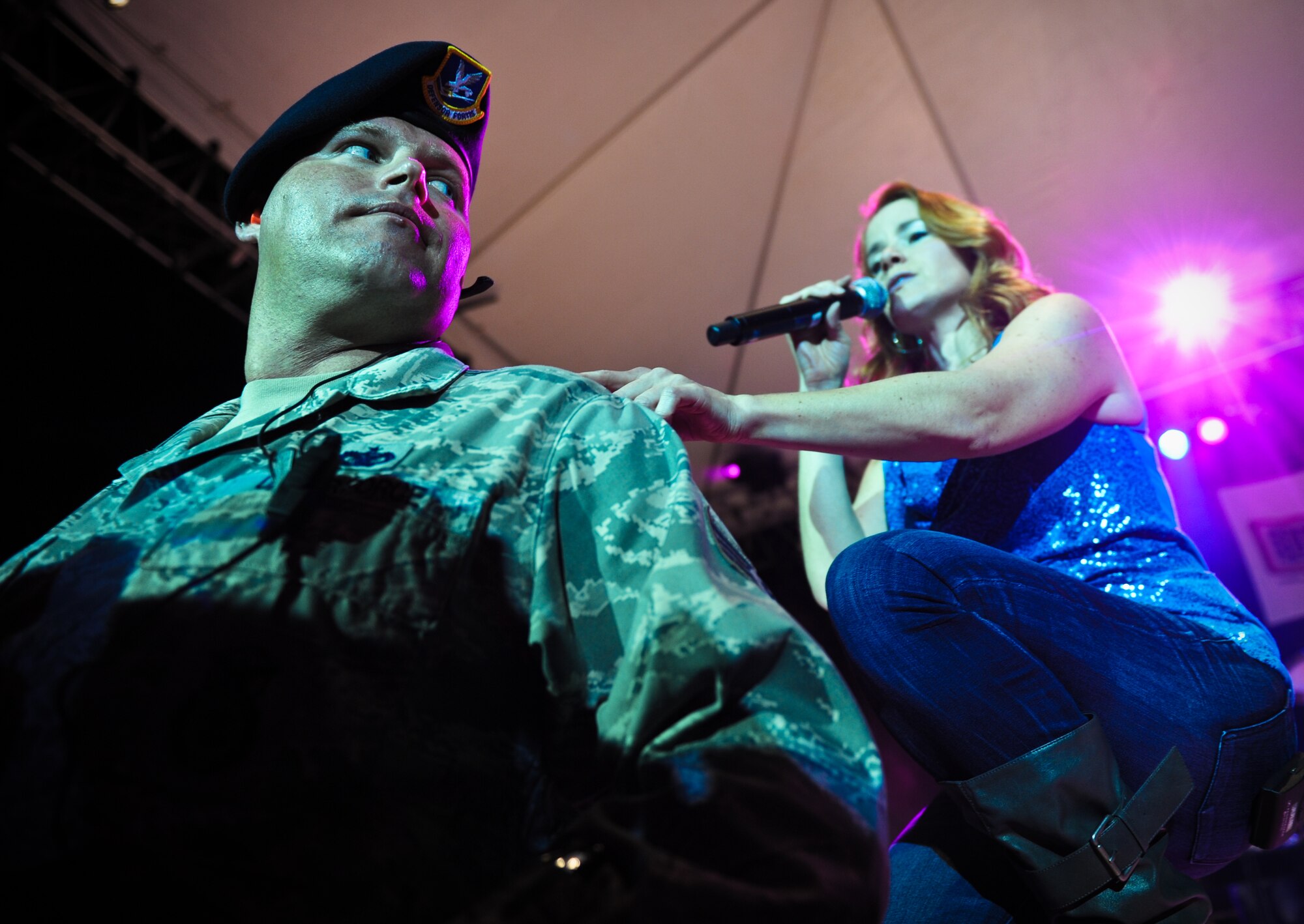 Julie Dutchak, a vocalist with the Lt. Dan Band, taps Staff Sgt. Jonathan Bielke, military working dog handler with the 647th Security Forces Squadron, to bring him on stage for a song during the Lt. Dan Band concert Feb. 10 at Joint Base Pearl Harbor-Hickam, Hawaii. Dutchak pulled Bielke on stage and sang "Natural Woman" by Aretha Franklin. (U.S. Air Force photo/Senior Airman Lauren Main)
