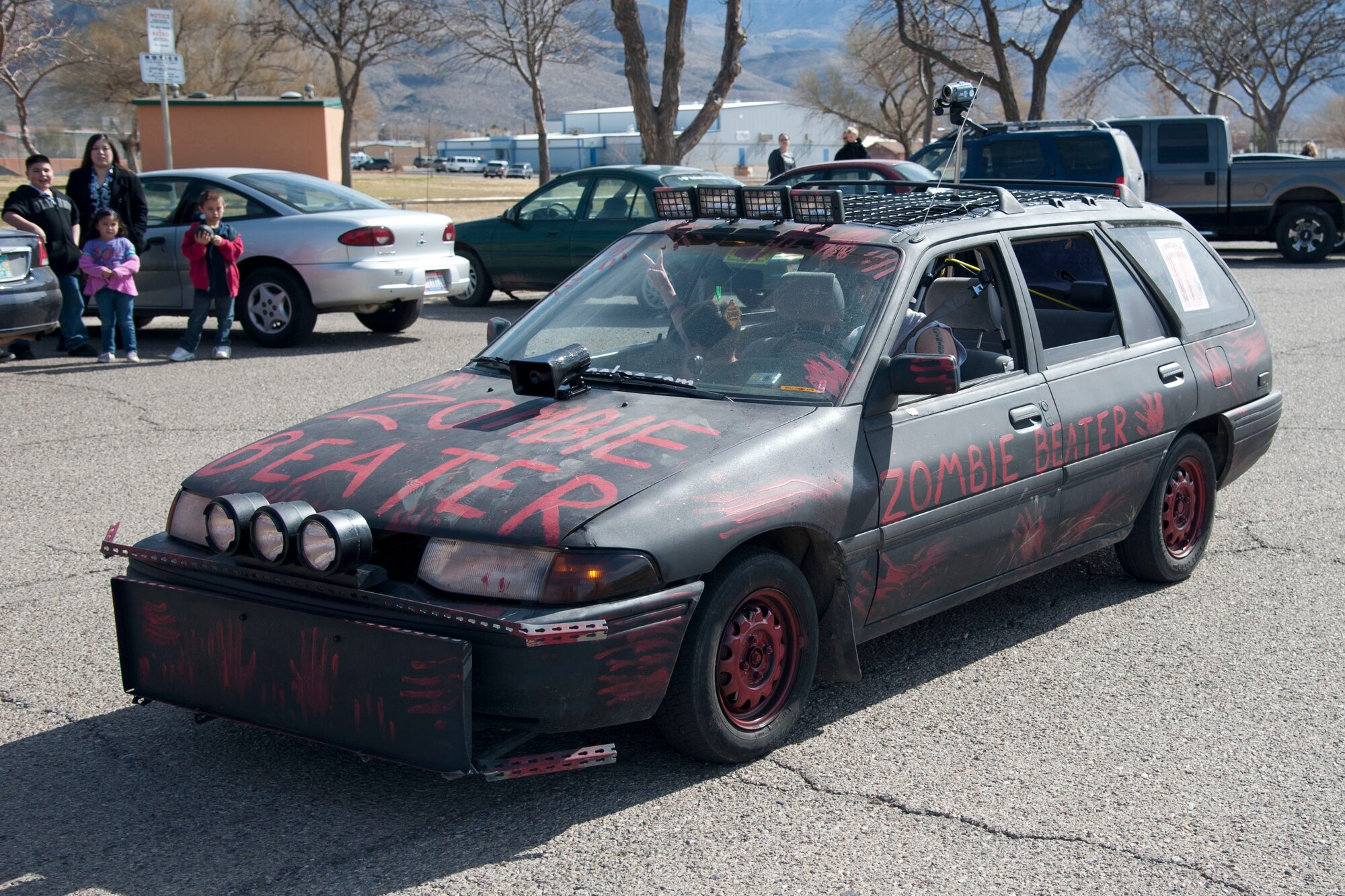 HOLLOMAN AIR FORCE BASE, N.M. – U.S. Airman First Class John Buckley tails behind participants of the Alamogordo Zombie Walk in his post-apocalyptic “Zombie Beater” Feb. 4. The event was in celebration of “Night of the Living Dead” director George A. Romero’s birthday, and was the first of its kind for the Holloman and Alamogordo communities. (U.S. Air Force photo by Airman 1st Class Anthony M. Ward/Released)
