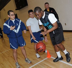 U.S. Air Force Airmen 1st Class Jeffrey Ganuza and Earl Norton, both from the 30th Intelligence Squadron, time and record the dribbling skills of Warren Watkins during a Special Olympics basketball event at Langley Air Force Base, Va., Feb. 11, 2012. The Special Olympics of Virginia is part of a global movement that serves more than 3.7 million athletes in more than 170 counties. (U.S. Air Force photo by Airman 1st Class Racheal Watson/Released)