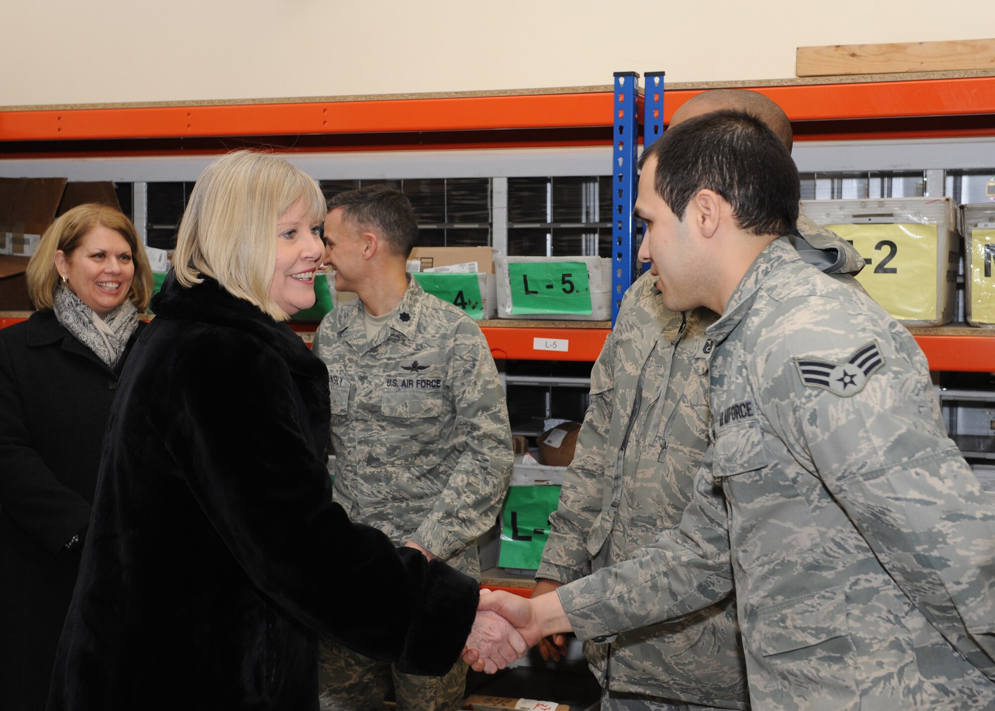 RAF MILDENHALL, England -- Suzie Schwartz, wife of Air Force Chief of Staff Gen. Norton Schwartz meets Senior Airman Josh Morales, 100th Communications Squadron, during a tour of the RAF Mildenhall Post Office here Feb. 10, 2011. She and the general visited RAF Mildenhall to attend an annual awards ceremony and meet with base leadership. (U.S. Air Force photo/Tech. Sgt. Neil X. Joiner) 
