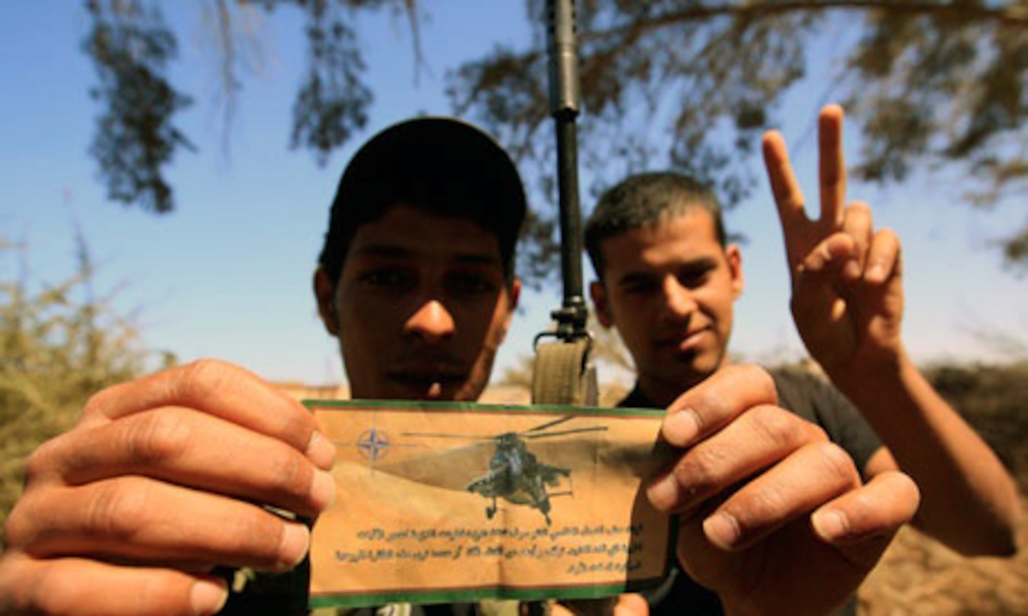 Two Libyan civilians show off a leaflet that was released from NATO assets during Operation Unified Protector. The 20th FW had the unique role of dropping leaflet bombs to give NATO messages for the safety of Libyan civilians. (U.S. Air Force courtesy photo/Released)