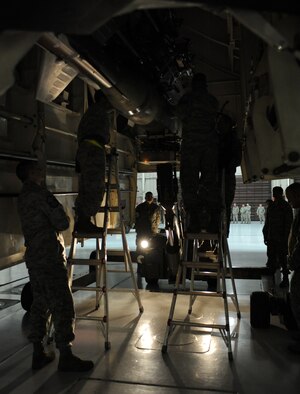 WHITEMAN AIR FORCE BASE, Mo. -- Weapons crew Airmen attach an inert GBU 28-C/B bomb to a B-2 Stealth Bomber during the annual load crew of the year competition Feb. 3. The competition is scored in four different areas to include dress and appearance, composite tool kit inspection, a written test, and a loading evaluation. To be eligible to compete the crews must have a zero deficiencies and must win Load Crew of the Quarter. The Airmen are assigned to the 509th Aircraft Maintenance Squadron. (U.S. Air Force photo/Senior Airman Laura Goodgame) 