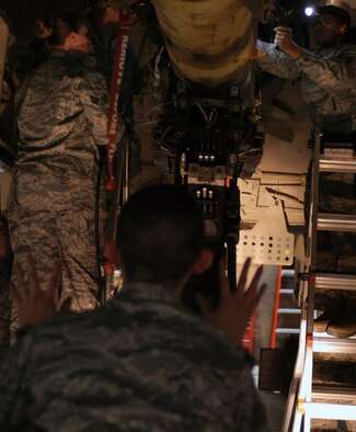 WHITEMAN AIR FORCE BASE, Mo. -- Senior Airman Siu Yu Leung holds up his hands for safety while his teammates attach an inert GBU 28-C/B bomb onto a B-2 Stealth Bomber during the annual load crew of the year competition Feb. 3. Not only does the competition recognize stellar weapons Airmen but it also hones their skills by meticulously carrying out their job while under the pressure of a timer. Leung is a weapons Airman assigned to the 509th Aircraft Maintenance Squadron. (U.S. Air Force photo/Senior Airman Laura Goodgame)