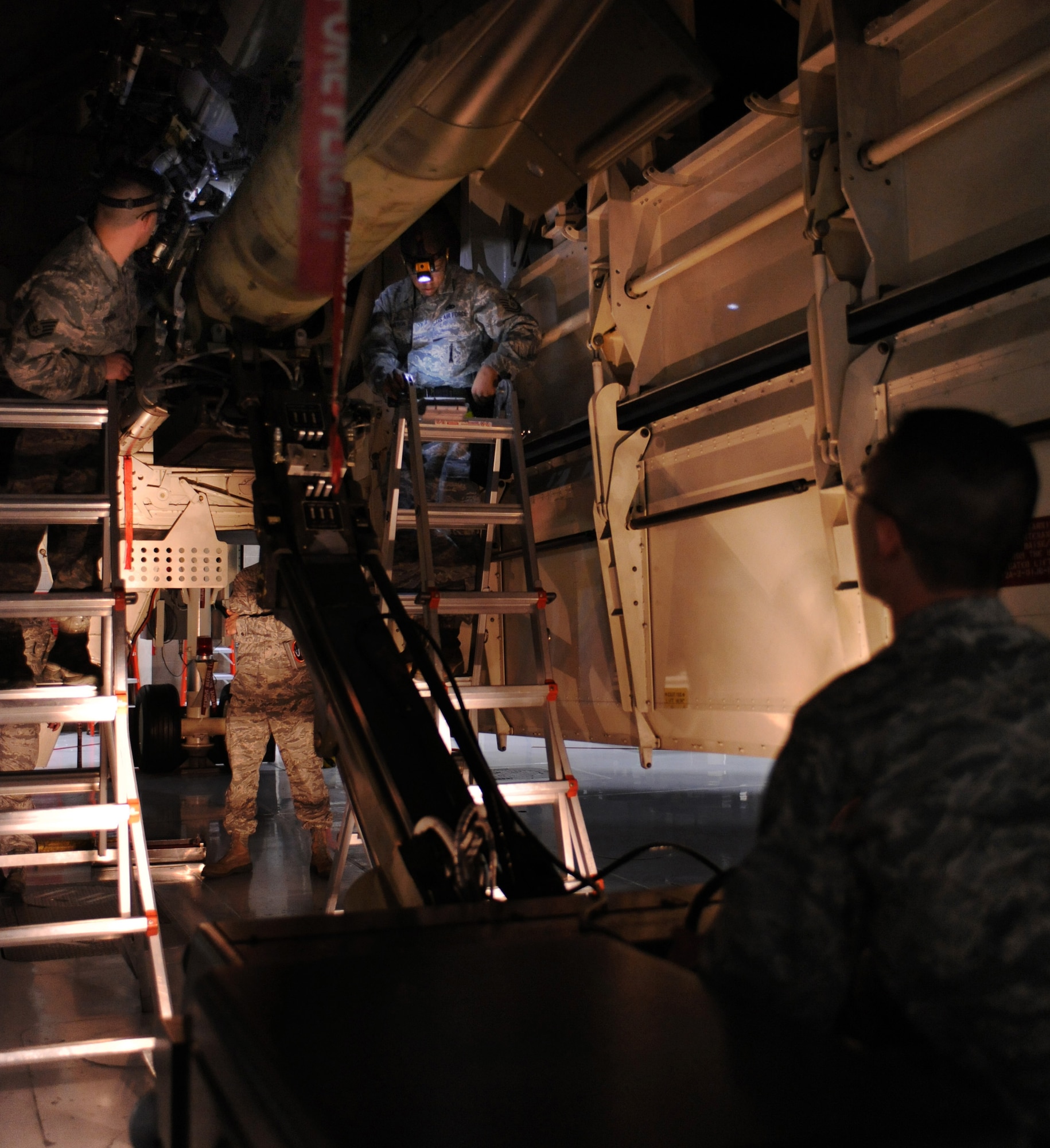 WHITEMAN AIR FORCE BASE, Mo. -- Weapons crew Airmen quickly attach an inert GBU 28-C/B bomb onto a B-2 Bomber during the annual load crew of the year competition Feb. 3. The Airmen must work meticulously during the timed event.  The competition is judged on several aspects to include zero deficiencies during the weapons load evaluation. The weapons Airmen are assigned to the 509th Aircraft Maintenance Squadron. (U.S. Air Force photo/Senior Airman Laura Goodgame) 