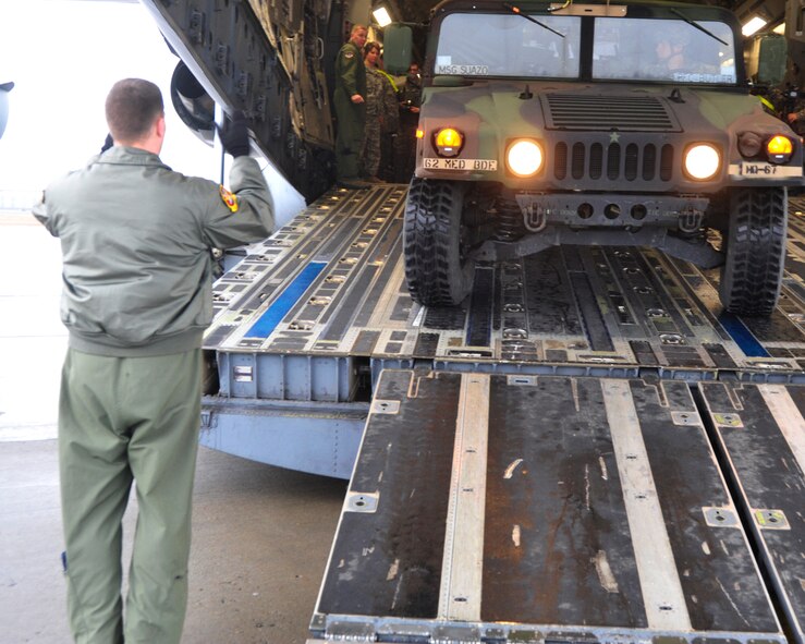 Tech. Sgt. Jeffrey Austin, 62nd Operations Support Squadron loadmaster, guides a Soldier from the 62nd Medical Brigade as he maneuvers a medical vehicle onto a C-17 Globemaster III Feb. 9, 2012, at Joint Base Lewis-McChord, Wash. This was part of an rapid deployment exercise. (U.S. Air Force photo/Staff Sgt. Frances Kriss)