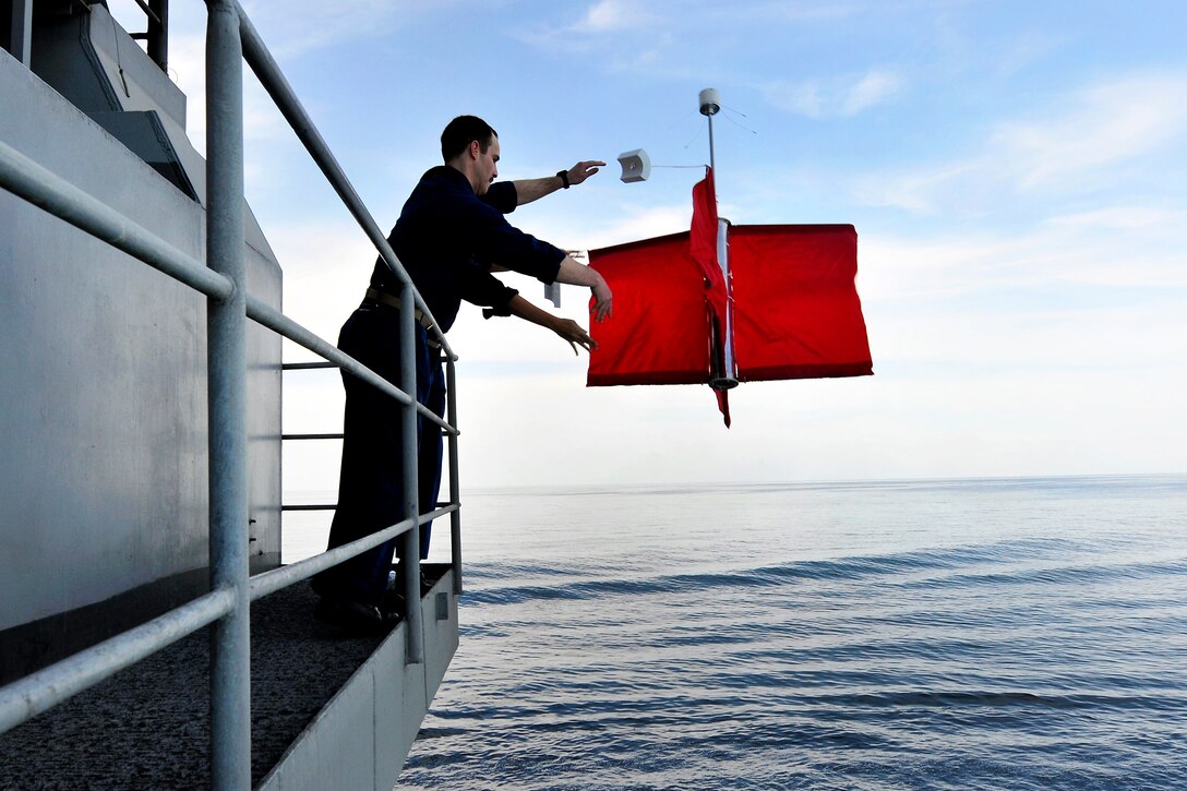 U.S. Navy Lt. Cmdrs. Shane Stoughton, left, and Ana Tempone deploy a drifting buoy used to measure ocean currents from the fantail aboard the USS Carl Vinson in the Arabian Sea, Feb. 9, 2012. Stoughton and Tempone are meteorology and oceanography officers.