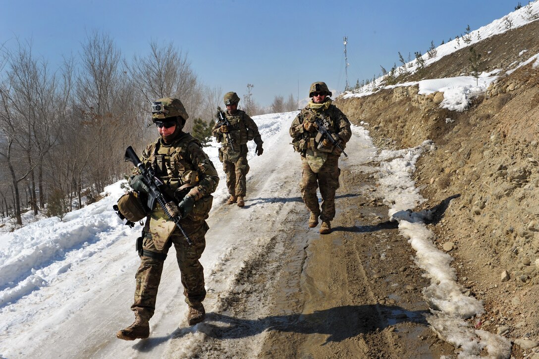 U.S. Army Sgt. Crystal Cornejo, left, and Staff Sgt. Farrell Thomey, right, and Sgt. Patrick Deleonguerrero, rear, maneuver down a hill caked with snow and ice during a presence patrol in Kabul, Afghanistan, Feb. 9, 2012. Cornejo, Thomey, and Deleonguerrero are assigned to the 1186th Military Police Company. Such patrols establish a coalition presence. They also help maintain positive community relationships and open lines of communication with Afghan residents to deter insurgent activity and address supply and equipment needs of local Afghan police.