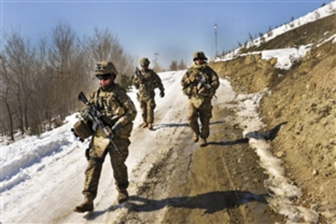 U.S. Army Sgt. Crystal Cornejo, left, and Staff Sgt. Farrell Thomey, right, and Sgt. Patrick Deleonguerrero, rear, maneuver down a snow and ice covered hill during a presence patrol in Kabul, Afghanistan, Feb. 9, 2012. Cornejo, Thomey, and Deleonguerrero are assigned to the 1186th Military Police Company.