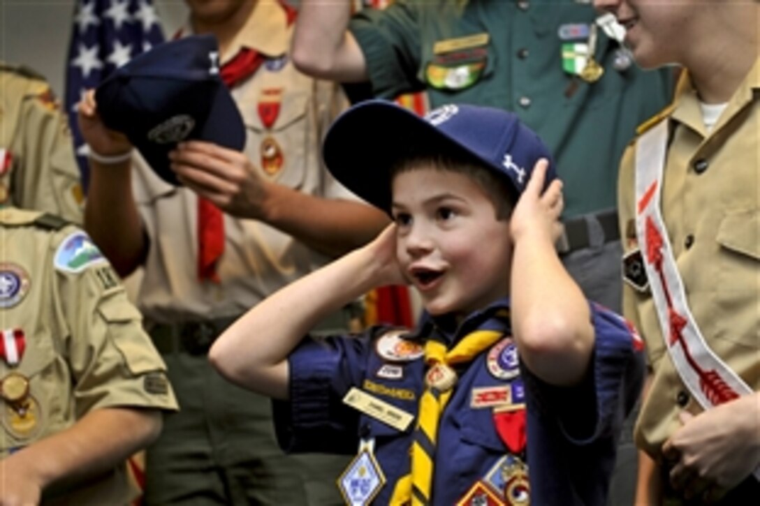 Cub Scout Daniel Logan Green, 8, reacts with excitement as he receives a Defense Department ball cap from Defense Secretary Leon E. Panetta at the Pentagon, Feb. 13, 2012. Green and a delegation of Boy Scouts gave Panetta a copy of the annual report for the Boy Scouts of America during their visit.