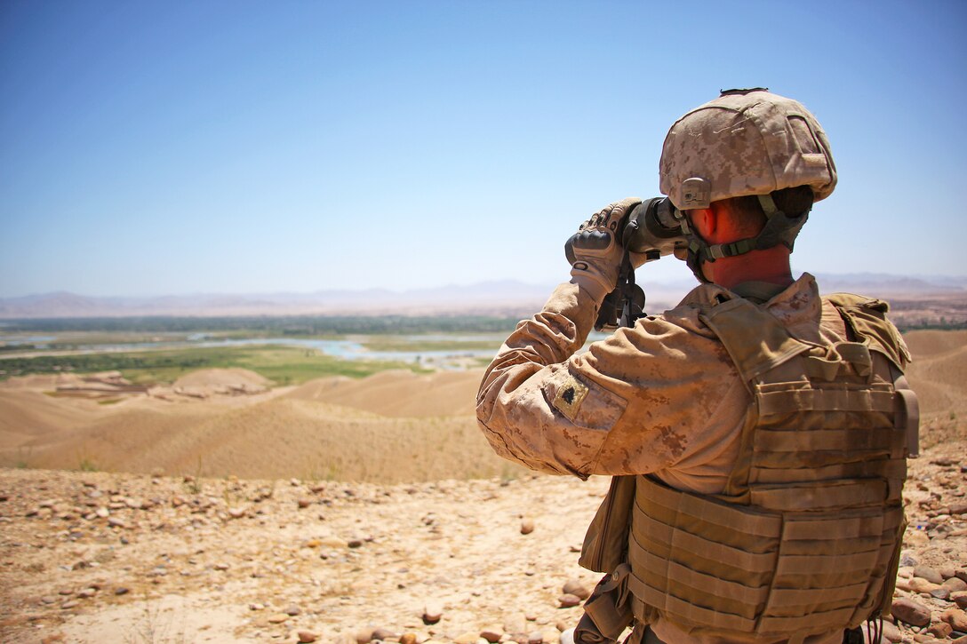Sgt. Joseph Graham, a forward observer with Fire Control Team 5, Supporting Arms Liaison Team Chuck, 2nd Air-Naval Gunfire Liaison Company monitors a village for insurgent activity, May 7. Marines with 2nd Radio Battalion, Task Force Belleau Wood, supply units like 2nd ANGLICO with indications and warning of insurgent activity.