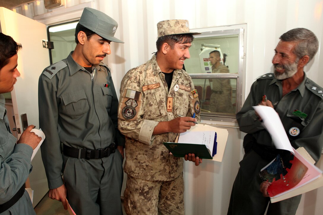 Afghan National Security Forces communications officers share a laugh after a communications shura, or meeting, between senior ANSF and coalition communications officers at Lashkar Gah, Helmand province, Sept. 21.  The shura marked the first time many of the various elements of the ANSF in Helmand province had met face-to-face at the same time.