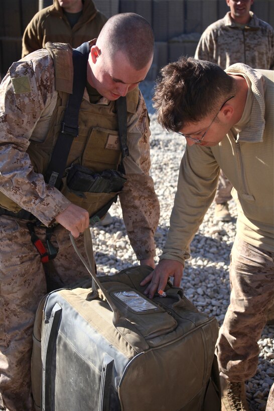 CAMP LEATHERNECK, Afghanistan-Cpl. Samuel Stark, radio operator, 1st Brigade, 5th Air Naval Gunfire Liaison Company (left), and Cpl. Hunter A. St Cyr, forward observer, 1st Brigade, 5th ANGLICO (right), unload their deployment bags aboard Patrol Base Hazrat, Nov. 28. The 5th ANGLICO took over 1st ANGLICO's area of operations, Dec. 4 after weeks of receiving briefs from 1st ANGLICO on the mission, successes and concerns in the area.