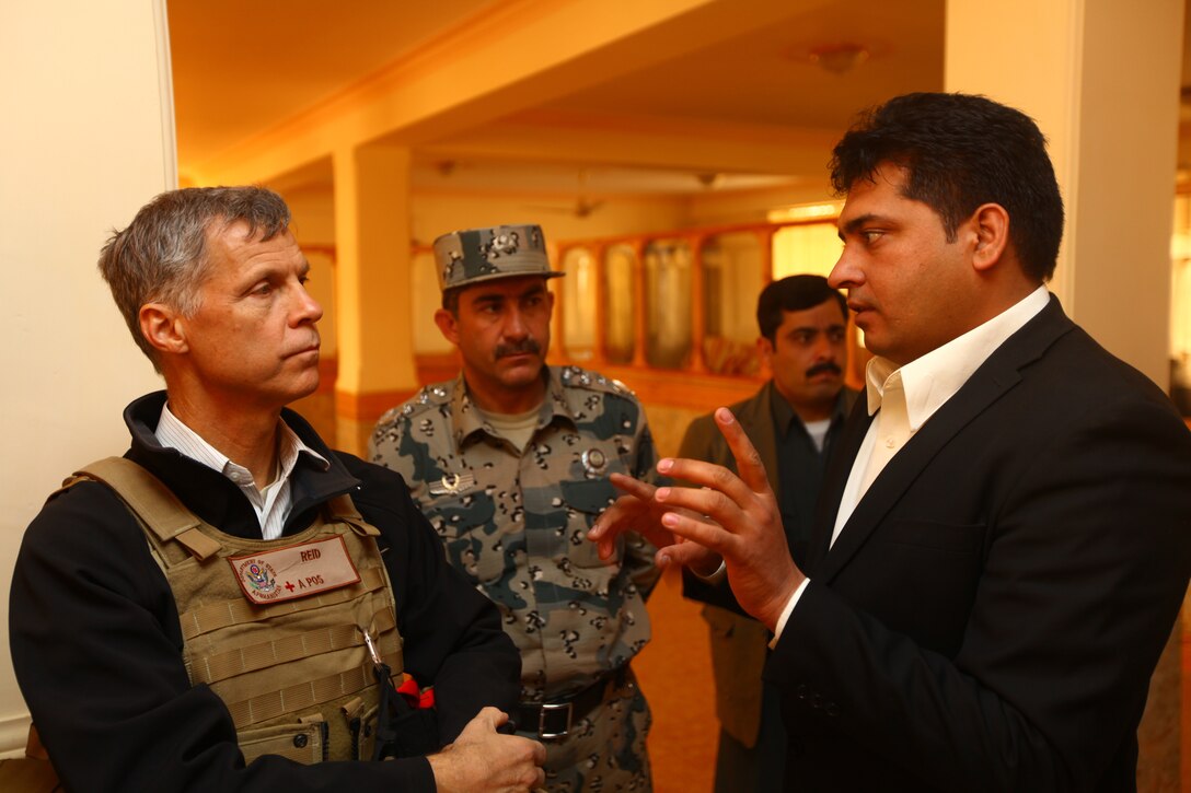 US State Department representative & Senior Civilian Representative Paul Reid talks with Afghan Border Police Kandak Commander Colonel Jowhari regarding security provisions in Nimroz province, Dec. 2. Reid and ISAF officials spent the day in Zaranj conducting construction site visits and discussing the future development of the region.