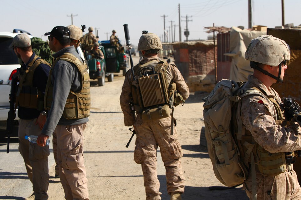 US Marines and civilians inspect their surroundings  in Zaranj, a border town between Iran and Afghanistan that is a major commercial hub for Nimroz province. ISAF and Afghan leaders spent the day in Zaranj to review plans to develop the capital city's infrastructure from commerce routes to waterways.