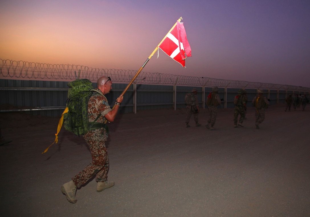First Lt. Rune Dyhr, Danish Force Protection Platoon, Danish Battle Group, carries the Danish flag during the Danish Contingent March aboard Camp Leatherneck, July 26. The DANCON march is a 15-mile endurance contest held by Danish troops wherever they are deployed.
