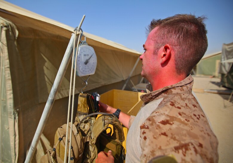 Petty Officer 3rd Class Lucien Vienot, a hospitalmen with the Joint Sustainment Academy Southwest, checks the weight of the gear he wore during the Danish Contingent March aboard Camp Leatherneck, July 26. Vienot, a native of Cincinnatti, ran the competition while wearing gear weighing more than 50 pounds. He was the first American to finish the challenge and the second participant to finish while wearing a full combat load. The DANCON march is a 15-mile endurance contest held by Danish troops wherever they are deployed.