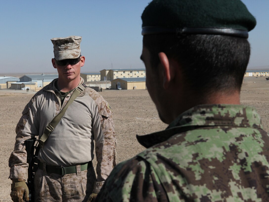 Sgt. Patrick Lynch, assistant operations chief, from Harrisburg, Penn., talks to a member of the Afghan National Army as he prepares to practice a dismounted patrol with other ANA soldiers aboard Forward Operating Base Delaram I, Feb. 14. Marines with Embedded Training Team, Regimental Combat Team 6 have a mission of training and advising members of the ANA.