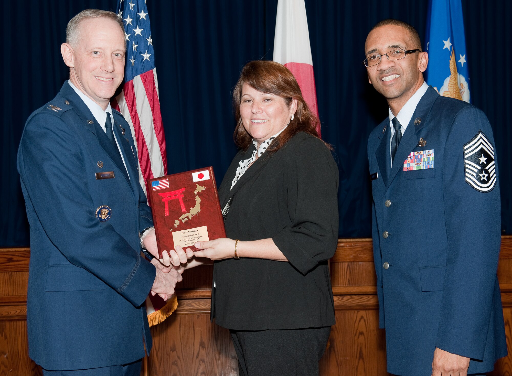 YOKOTA AIR BASE, Japan -- Tammy Hogue, 374th Comptroller Squadron, receives US/JN category I civilian of the quarter plaque during Team Yokota 4th quarterly award ceremony, Feb. 14, 2012 at Yokota Air Base, Japan. Col. Otto Feather, 374th Airlift Wing commander, and Command Chief Master Sgt. Ronald Draper, 374th Airlift Wing, presents the award to Hogue during the ceremony. (U.S. Air Force photo/Osakabe Yasuo)