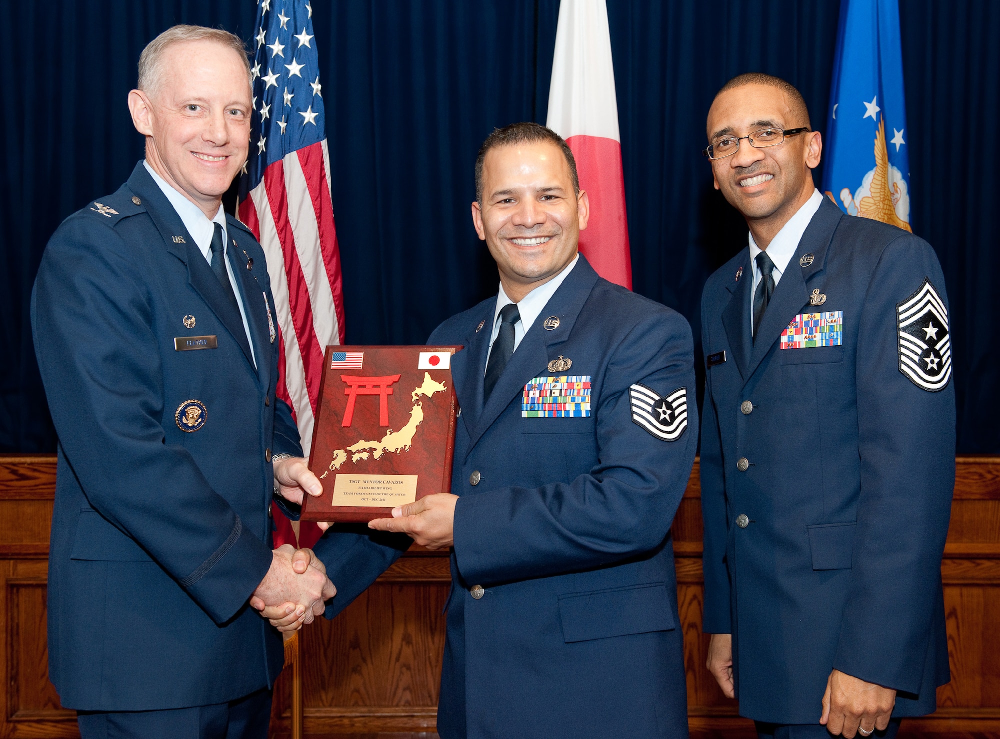 YOKOTA AIR BASE, Japan -- (left to right) Tech. Sgt. Mentor Cavazos, 374th Communications Squadron, receives NCO of the quarter plaque during Team Yokota 4th quarterly award ceremony, Feb. 14, 2012 at Yokota Air Base, Japan. Col. Otto Feather, 374th Airlift Wing commander, and Command Chief Master Sgt. Ronald Draper, 374th Airlift Wing, presents the award to Cavazos during the ceremony. (U.S. Air Force photo/Osakabe Yasuo)