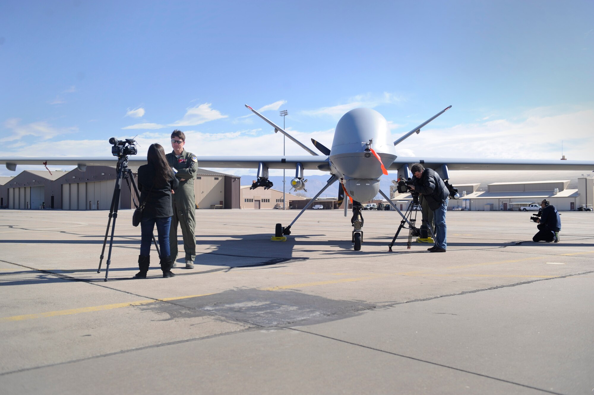 HOLLOMAN AIR FORCE BASE, N.M. -- Local and international media outlets film and interview Royal Air Force Sqn Ldr Dex (last name withheld), a 29th Attack Squadron MQ-9 Reaper sensor operator, on the flightline here Feb. 9. Media visited Holloman to discuss the training mission here and the capabilities of remotely piloted aircraft. Surnames of the RPA crew members are withheld due to operational security constraints. (U.S. Air Force photo by Staff Sgt. Carolyn Herrick/Released)