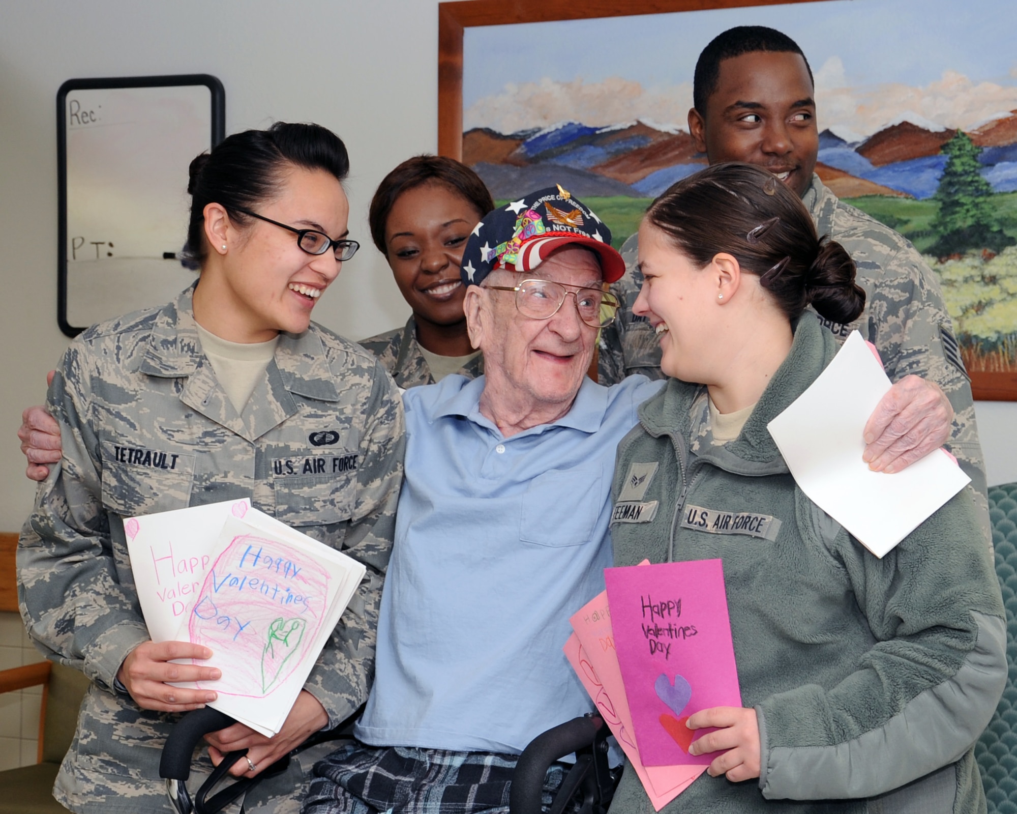 CLINTON, Okla. — Bud Bowman (center), U.S. Army veteran laughs with Senior Airman Nicole Feeman (right), Airman 1st Class Angelique Tetrault (left), Staff Sgt. Ricky Day (top right), contract administrators from the 97th Contracting Squadron, and Tech. Sgt. LaKisha Mount, 97th Medical Operations Squadron clinic operations flight chief, during the “Valentines for Vets” visit to Clinton Veteran’s Center Feb. 14, 2012. A total of 29 volunteers from Altus Air Force Base traveled to Clinton, Okla. and distributed out Valentine’s Day cards made by Altus elementary school students. (U.S. Air Force photo by Senior Airman Leandra D. Stepp / 97th Air Mobility Wing Public Affairs / Released)   