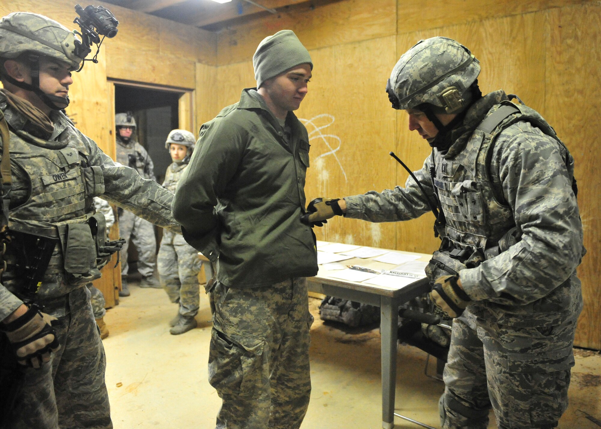 U.S. Air Force Capt. Nathan Sandmann, 824th Base Defense Squadron physicians assistant, right, checks a detainee for injuries during Joint Operations Access Exercise 12-01 in Fort Bragg, N.C., Feb. 12. Sandmann jump with 18 other airborne members from the 824th BDS and continued to their main objective where they had to set-up a detainee control point and help evacuate American civilians out of the hostile environment. (U.S. Air Force photo by Staff Sgt. Stephanie Mancha/Released)