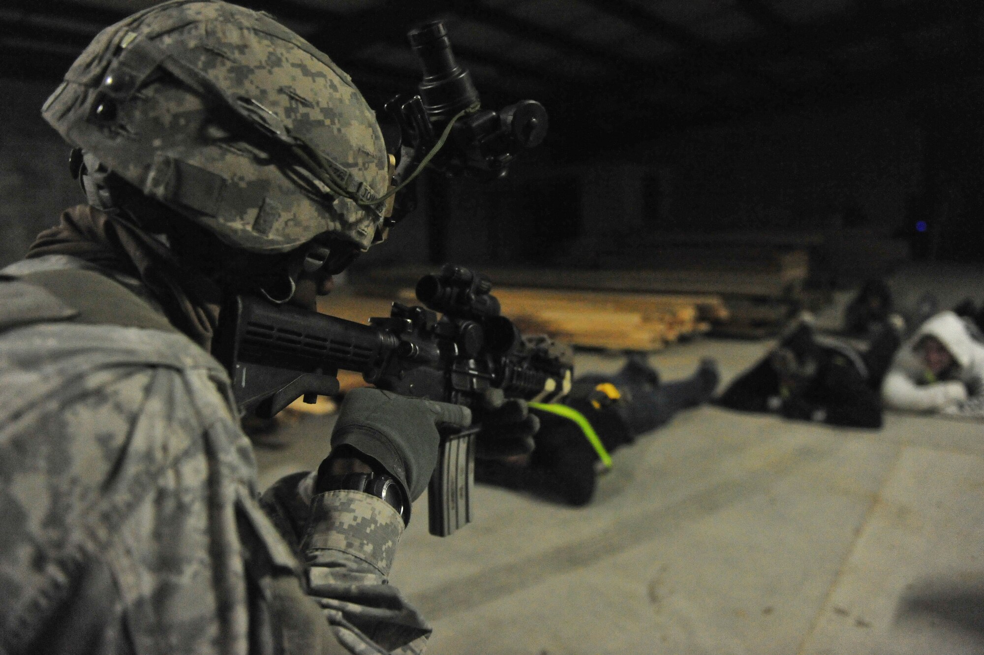 U.S. Army Pfc. Deshawn Townes, 2nd Battalion, 505th Parachute Infantry Regiment, 82nd Airborne Division, watches detainees during Joint Operations Access Exercise 12-01 in Fort Bragg, N.C., Feb. 12. The unit was part of the forward operating team that secured the building and searched the occupants after their jump out of the C-130 Hercules. (U.S. Air Force photo by Staff Sgt. Stephanie Mancha/Released)