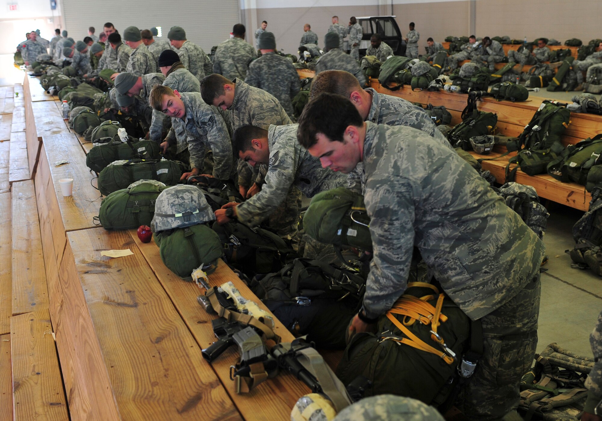 U.S. Air Force Airmen with the 824th Base Defense Squadron rig their gear before a jump during Joint Operations Access Exercise 12-01 in Pope Army Airfield, N.C., Feb. 12. The airborne members perform a pre-flight check to ensure their gear is ready before they board the flight. (U.S. Air Force photo by Staff Sgt. Stephanie Mancha/Released)