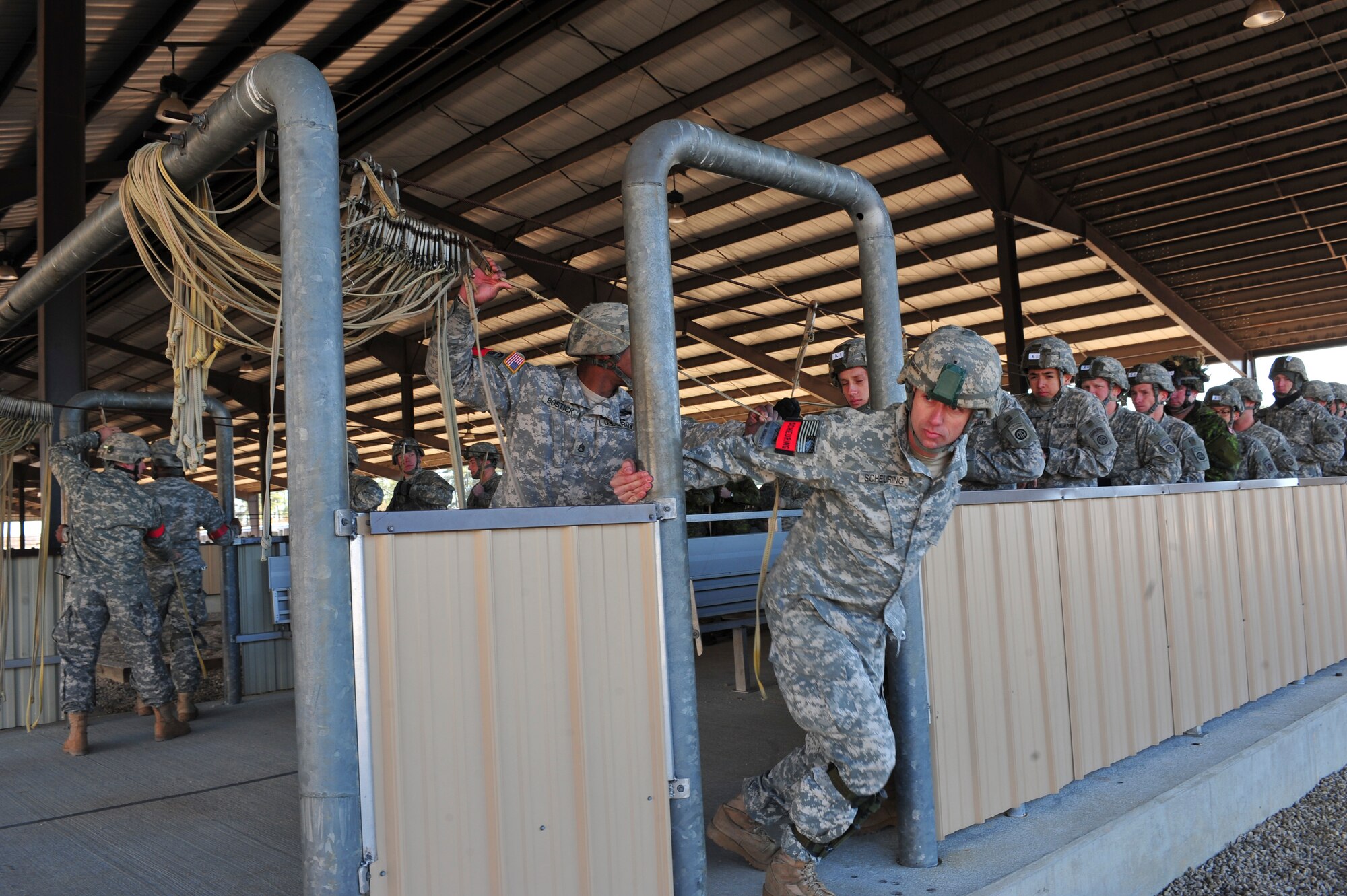 U.S. Army Warrant Officer Brian Scheuring, 2nd Brigade Combat Team, 82nd Airborne Division jumpmaster, prepares to exit the servicemembers from the door during pre-jump training during Joint Operations Access Exercise 12-01 in Pope Army Airfield, N.C., Feb. 12. The coalition forces run through different steps of a jump to ensure there are no accidents. (U.S. Air Force photo by Staff Sgt. Stephanie Mancha/Released)