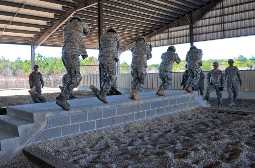 U.S. Air Force Airmen with the 824th Base Defense Squadron along with U.S. Army soldiers attached to Headquarters and Headquarters Company, 3rd Brigade Special Troops Battalion, 3rd Brigade Combat Team, 82nd Airborne Division, practice parachute landing training before their jump during Joint Operations Access Exercise 12-01 in Pope Army Airfield, N.C., Feb. 12. This training provides airborne members with safety awareness during their static line jumps. (U.S. Air Force photo by Staff Sgt. Stephanie Mancha/Released)