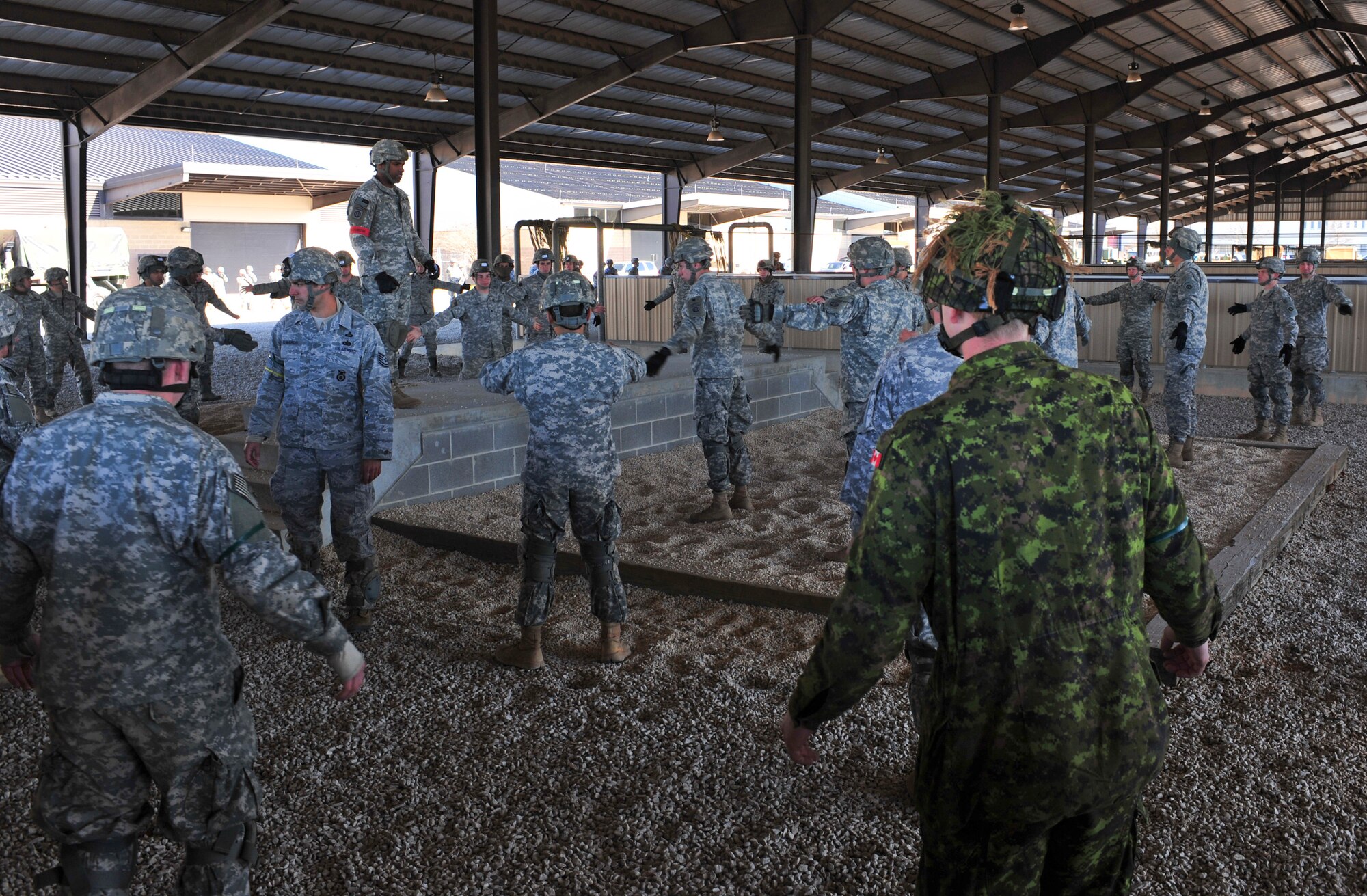 U.S. Army Soldiers and Air Force Airmen along with the Royal Canadian Regiment participate in a pre-jump training before their night jump during a Joint Operations Access Exercise 12-01 in Pope Army Airfield, N.C., Feb. 12. The service members practiced body posture and landing procedures to ensure the safety of the airborne members. (U.S. Air Force photo by Staff Sgt. Stephanie Mancha/Released)