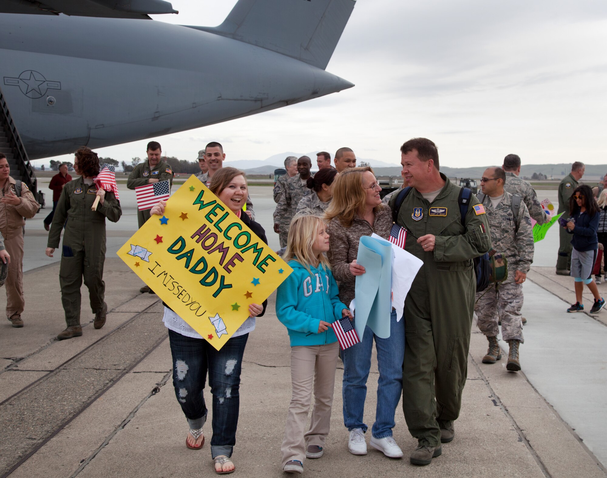 TRAVIS AIR FORCE BASE, Calif. -- Senior Master Sgt. Jimmy Grant, a loadmaster with the 312th Airlift Squadron, is greeted by family and friends upon return to Travis Air Force Base, Calif., Feb. 12, 2012, after deploying in support Operation Enduring Freedom. Aviators from the reserve 312th AS and active-duty 22th Airlift Squadron deployed with a Travis C-5B Galaxy to an undisclosed location to airlift cargo in and out of Afghanistan.   (U.S. Air Force photo / Lt. Col Robert Couse-Baker)