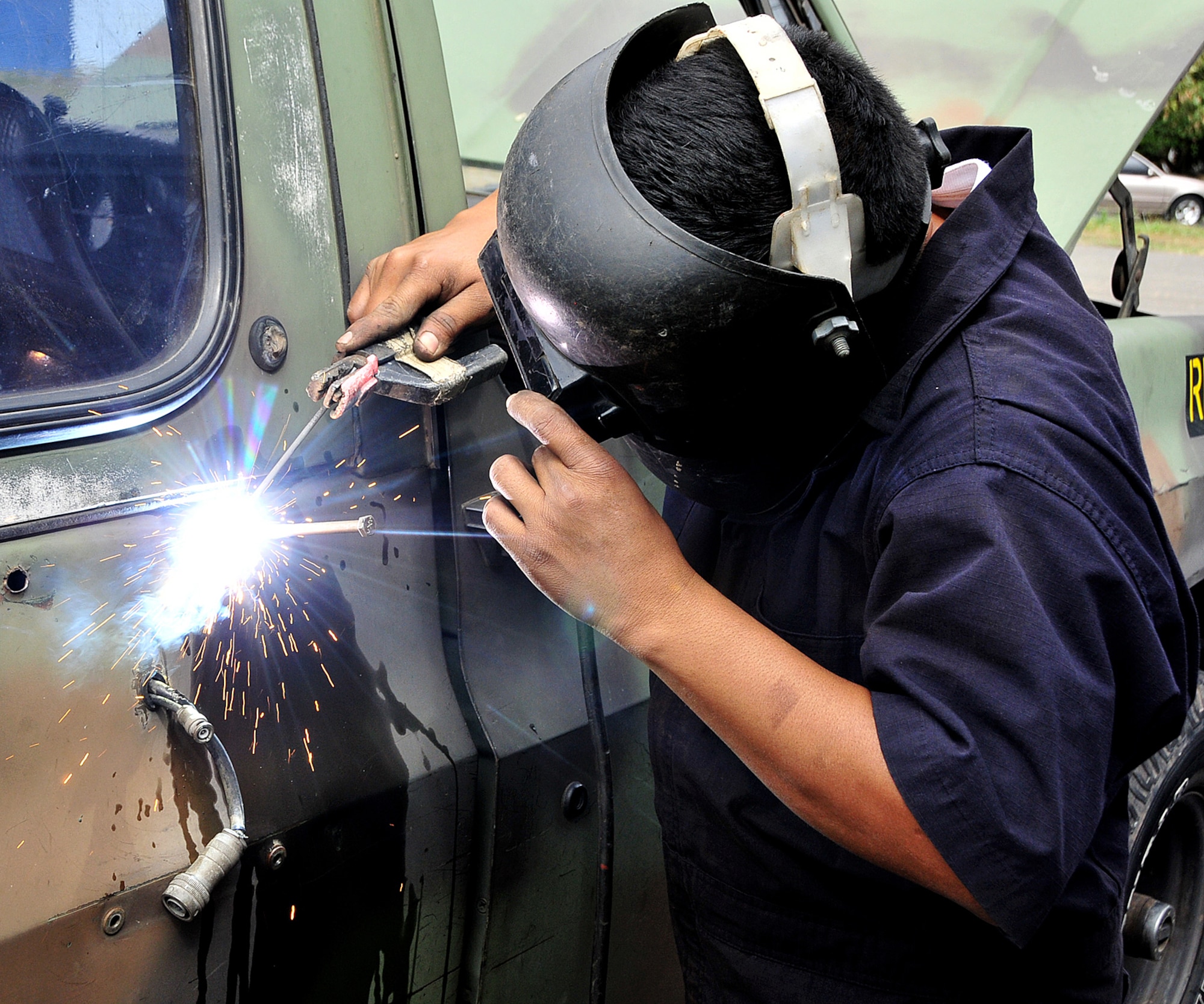 A Honduran Air Force metal worker fixes the holes needed to mount an antennae bracket on the tactical communication vehicle at Col. Hernán Acosta Mejia Air Base, Tegucigalpa, Honduras, Feb. 7.  Approximately 20 members of Air Mobility Command's 571st Mobility Support Advisory Squadron, 615th Contingency Response Wing, Travis AFB, Calif., are participating in a month-long Building Partner Capacity mission in Tegucigalpa, Honduras.  (U.S. Air Force photo by Tech. Sgt. Lesley Waters)