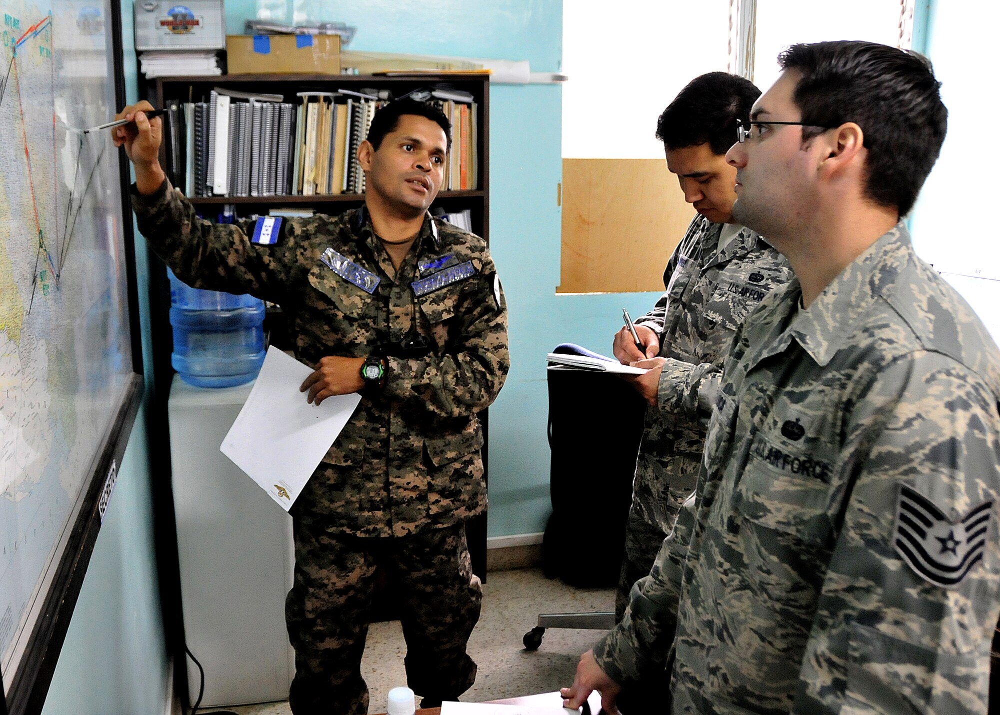 A Honduran Air Force communication technician shows Tech. Sgt. Claudio Winfree and Tech. Sgt. Brian De Luca, 571st Mobility Support Advisory Squadron air advisors, the location of all the FAH communications sites, at Col. Hernán Acosta Mejia Air Base, Tegucigalpa, Honduras, Feb. 7.  The MSAS Airmen, representing 15 Air Force specialties, are working side-by-side with Honduran Air Force members in developing seven core competencies to include air base defense, air traffic control, aircraft maintenance, aircrew survival, communications, generator maintenance and safety.  (U.S. Air Force photo by Tech. Sgt. Lesley Waters)
