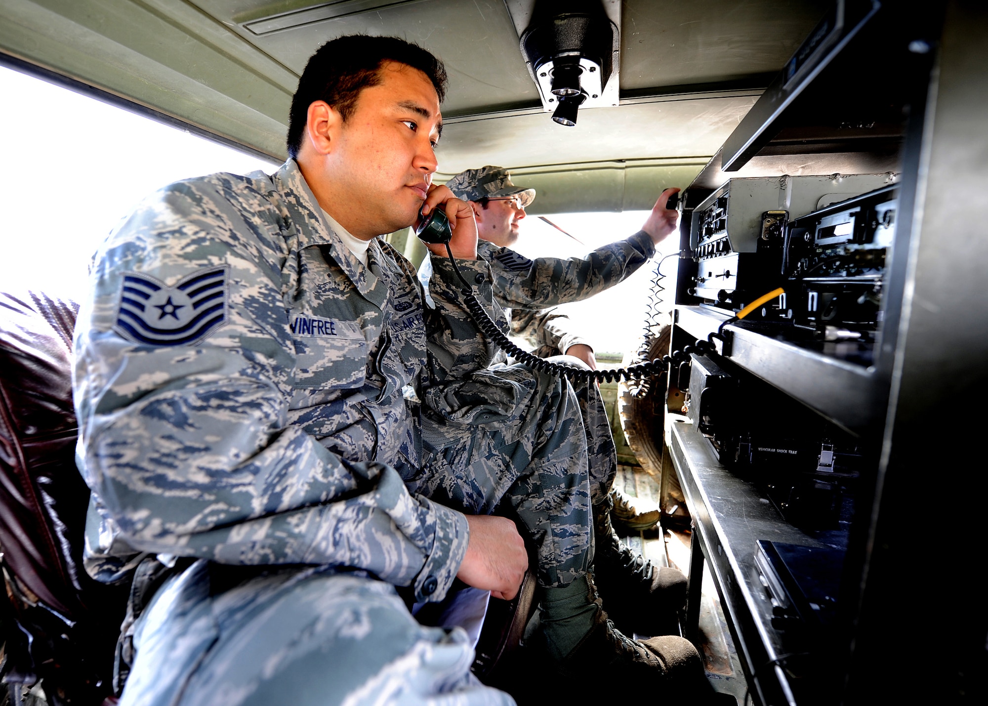 Technical Sgt. Claudio Winfree and Tech. Sgt. Brian De Luca, 571st Mobility Support Advisory Squadron air advisors, perform an operations check on the communication equipment in the Honduran Air Force tactical communication vehicle at Col. Hernán Acosta Mejia Air Base, Tegucigalpa, Honduras, Feb. 7.  (U.S. Air Force photo by Tech. Sgt. Lesley Waters)