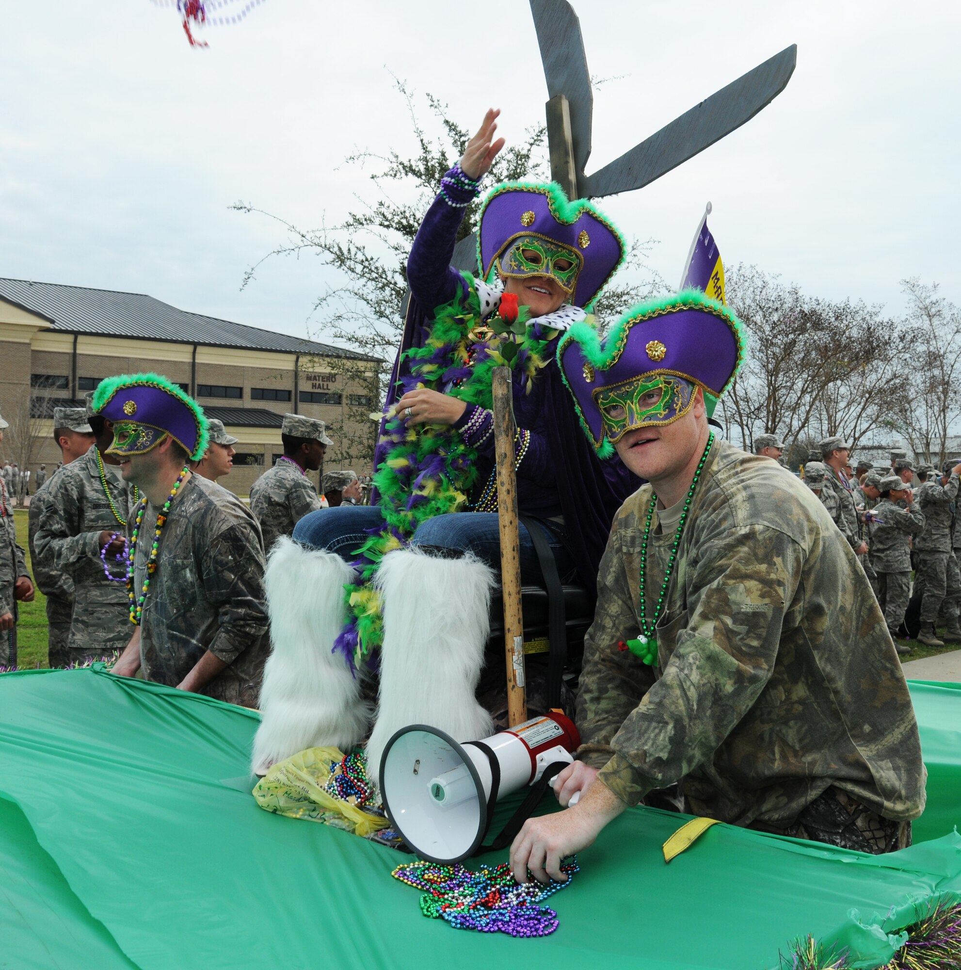 Tech. Sgt. Jason McAlpin and Staff Sgts. April Omara and Brady Dunbar, 334th Training Squadron “Krewe of the Swamp People,” throw beads to the crowd during the 81st Training Group Mardi Gras parade Feb. 10, 2012.  The parade stretched from Thomson Hall to Matero Hall at Keesler Air Force Base, Biloxi, Miss.  (U.S. Air Force photo by Kemberly Groue)
