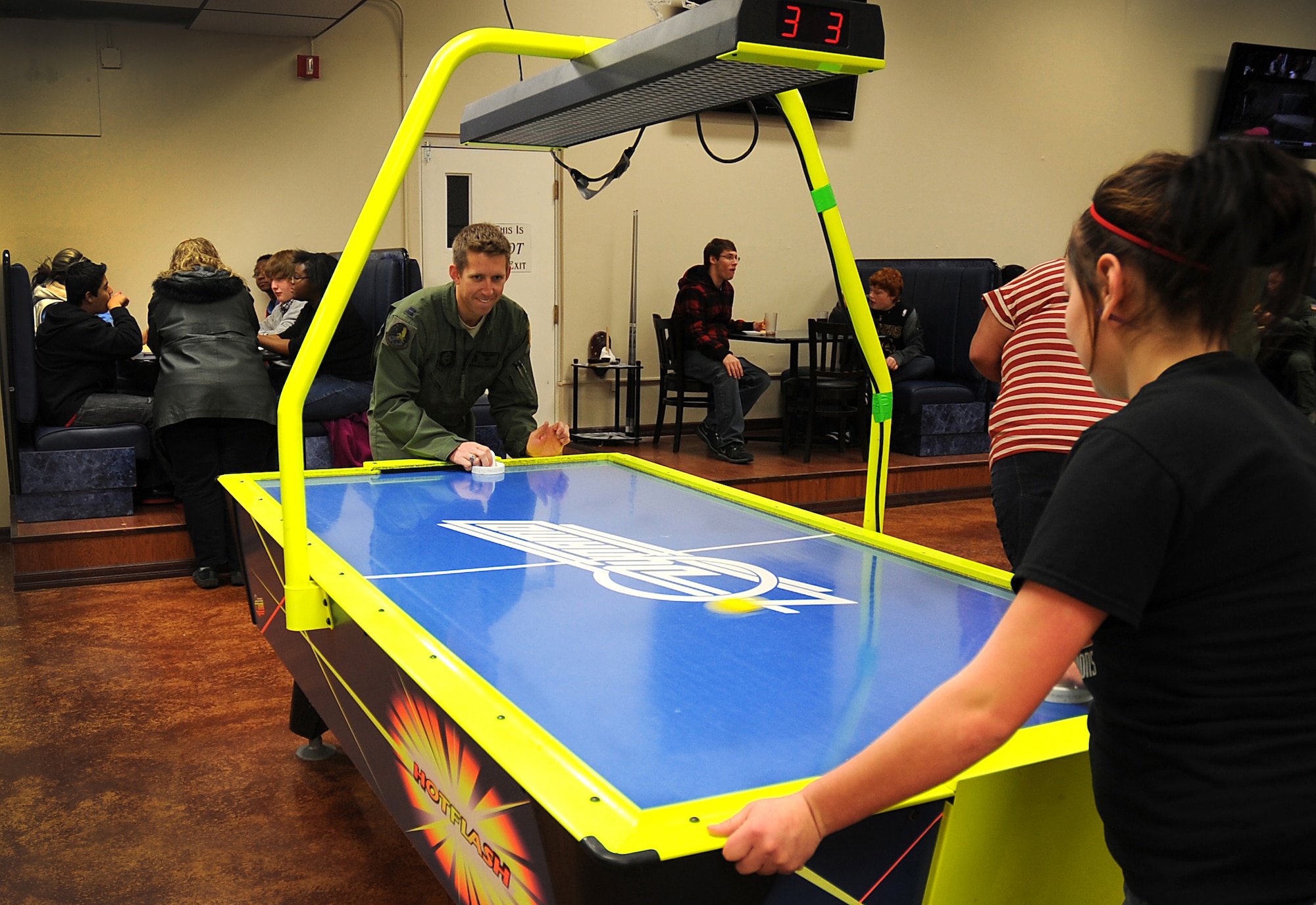 U.S. Air Force Capt. Matthew Beaubien, 318th Special Operations Squadron pilot, challenges a young girl from the New Mexico Baptist Children?s Home in Portales, N.M., to a game of air-hockey at The Drop Zone at Cannon Air Force Base, N.M., Feb. 11, 2012. A group of kids from the home were invited by Cannon Air Commandos to enjoy pizza, games, a base tour and bowling at Cannon. (U.S. Air Force photo by Airman 1st Class Alexxis Pons Abascal)  
