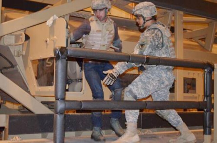 Michael Piller (left) Junior Civilian Deployment Program intern, and Army Capt. Ramon Ramos, 900th Contingency Contracting Battalion, exit an upended RG-33 mine-resistant light armored vehicle during a Jan. 28, 2012, exercise to prepare contingency contracting officers for deployed operations. (Courtesy photo) 