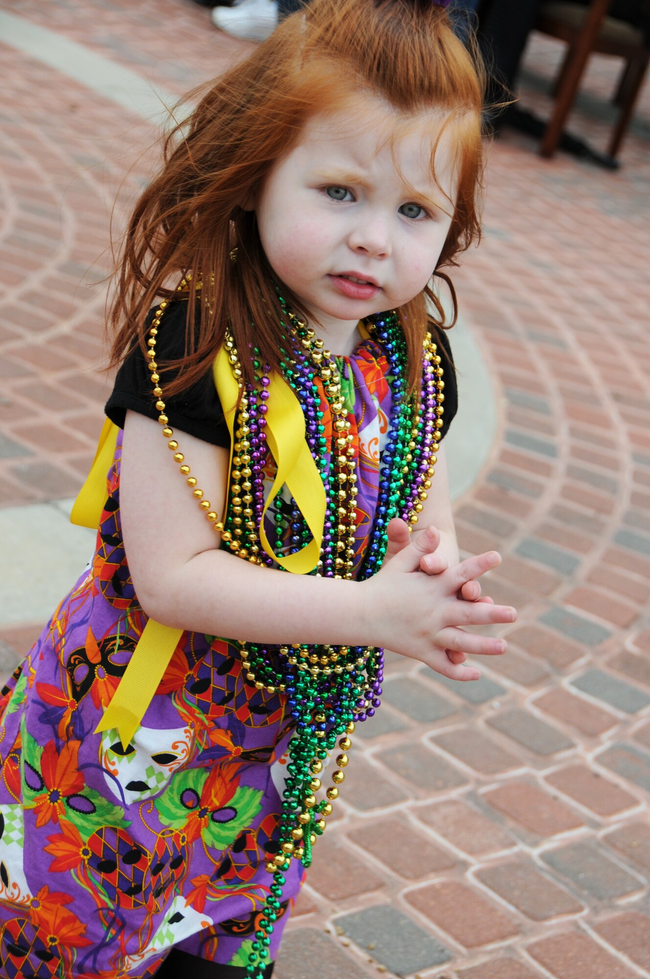 Three-year-old Madalyn Cooper, daughter of Tech. Sgt. Stephen and Tonya Cooper, 336th Training Squadron, waits for more floats to pass during the 81st Training Group Mardi Gras parade Feb. 10, 2012, between Thomson Hall and Matero Hall at Keesler Air Force Base, Biloxi, Miss.  (U.S. Air Force photo by Kemberly Groue)