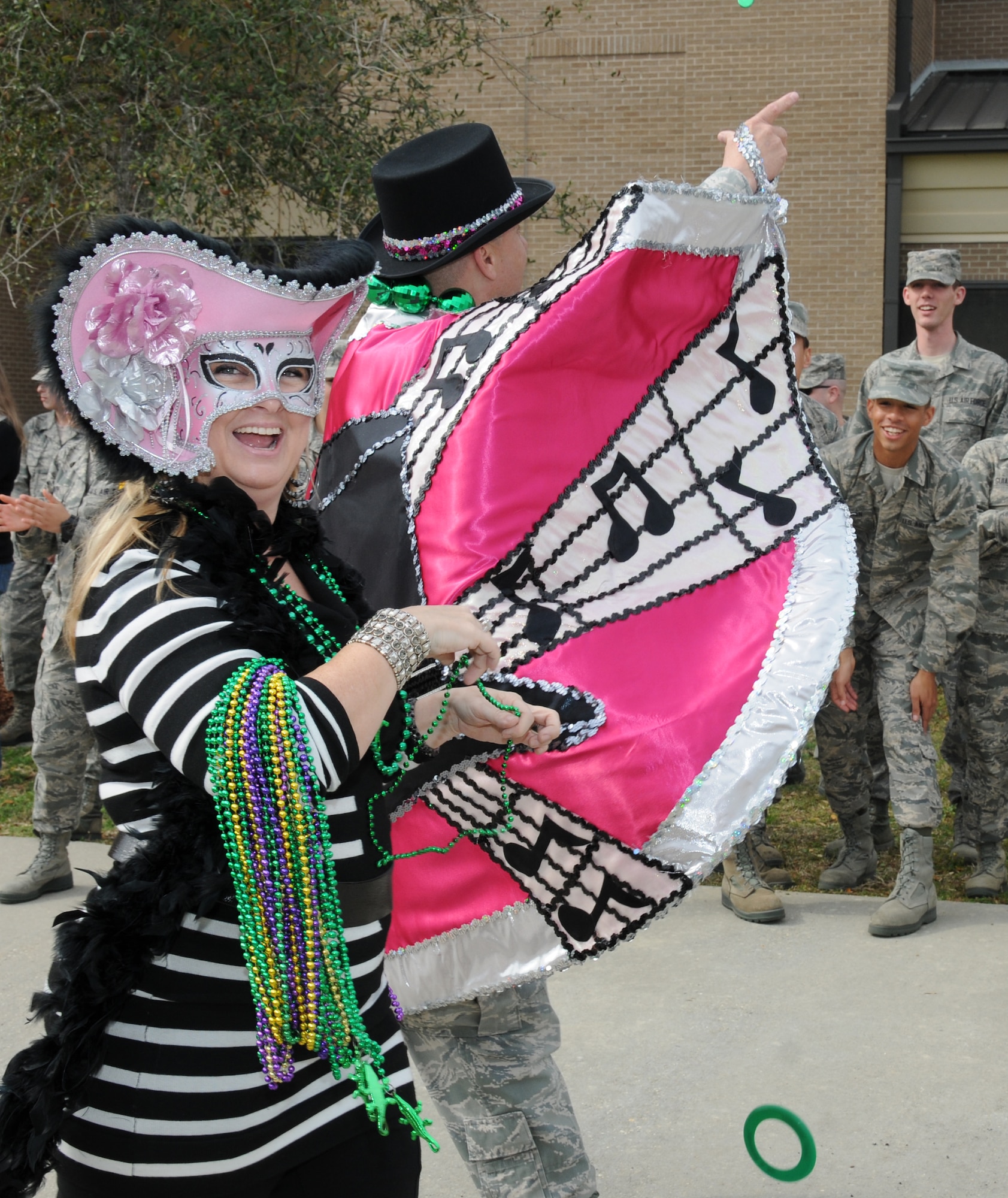 Jo and Lt. Col. Jeffrey McLemore, 334th Training Squadron commander, throw beads to the Airmen lining the parade route during the 81st Training Group Mardi Gras parade Feb. 10, 2012, between Thomson Hall and Matero Hall at Keesler Air Force Base, Biloxi, Miss.   (U.S. Air Force photo by Kemberly Groue)